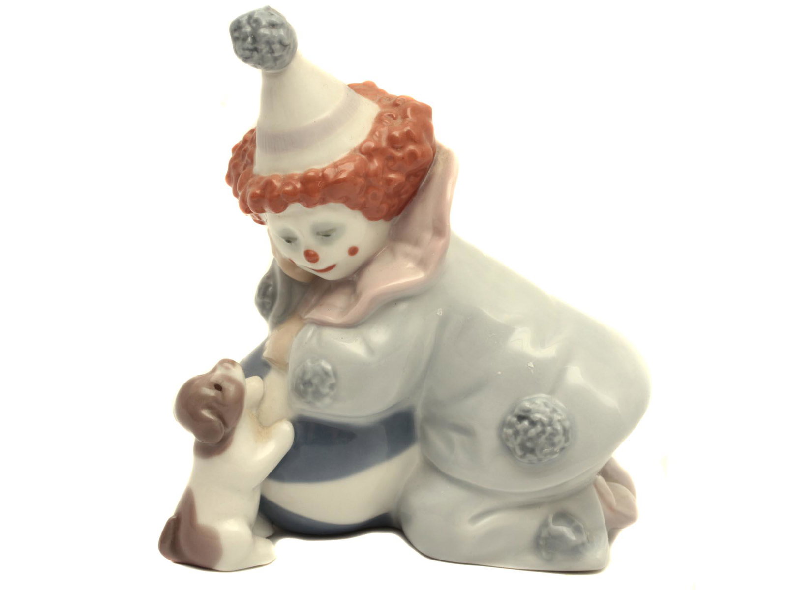 A VINTAGE SPANISH LLADRO DAISA PORCELAIN FIGURINE: A charming porcelain figurine depicting Pierrot with a puppy and a ball. Glazed finish. Stamped on the base with "LLADRO /HAND MADE IN SPAIN / DAISA 1985. Dimensions: H: 5 in., (12.7 cm.)