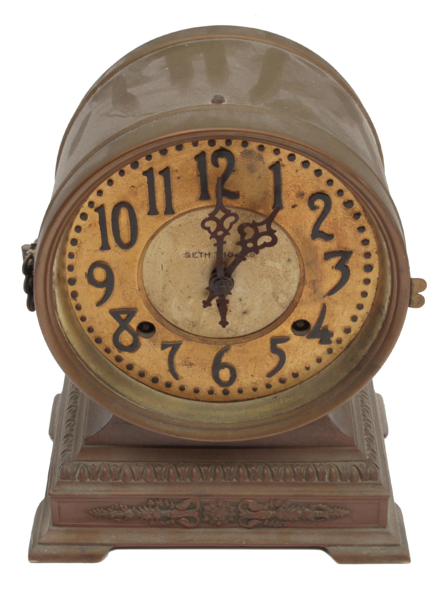 A SETH THOMAS MANTLE CLOCK EARLY 20TH C: A vintage American mantle clock by Seth Thomas. Brass dial marked "Seth Thomas". Metal case, round dial on a stand decorated with relief. Dimensions: H: 10 1/2 in., (27 cm.)