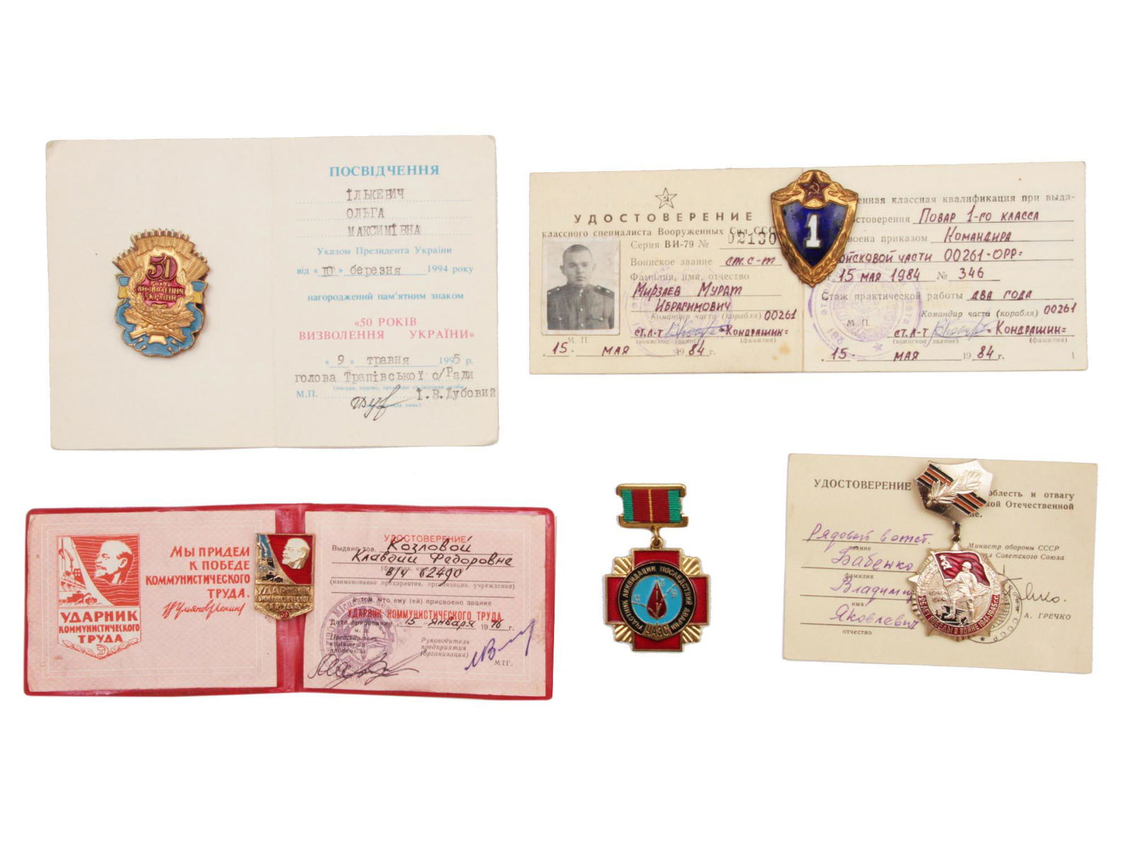 A DOCUMENTED GROUP OF SOVIET AWARDS: The lot includes: a badge "50 years of liberation of Ukraine" with documents in the name of Olga Maksimovna Ilkevich, a badge of the 1st class cook with documents in the name of Mirzaev Murat Ibrasimo