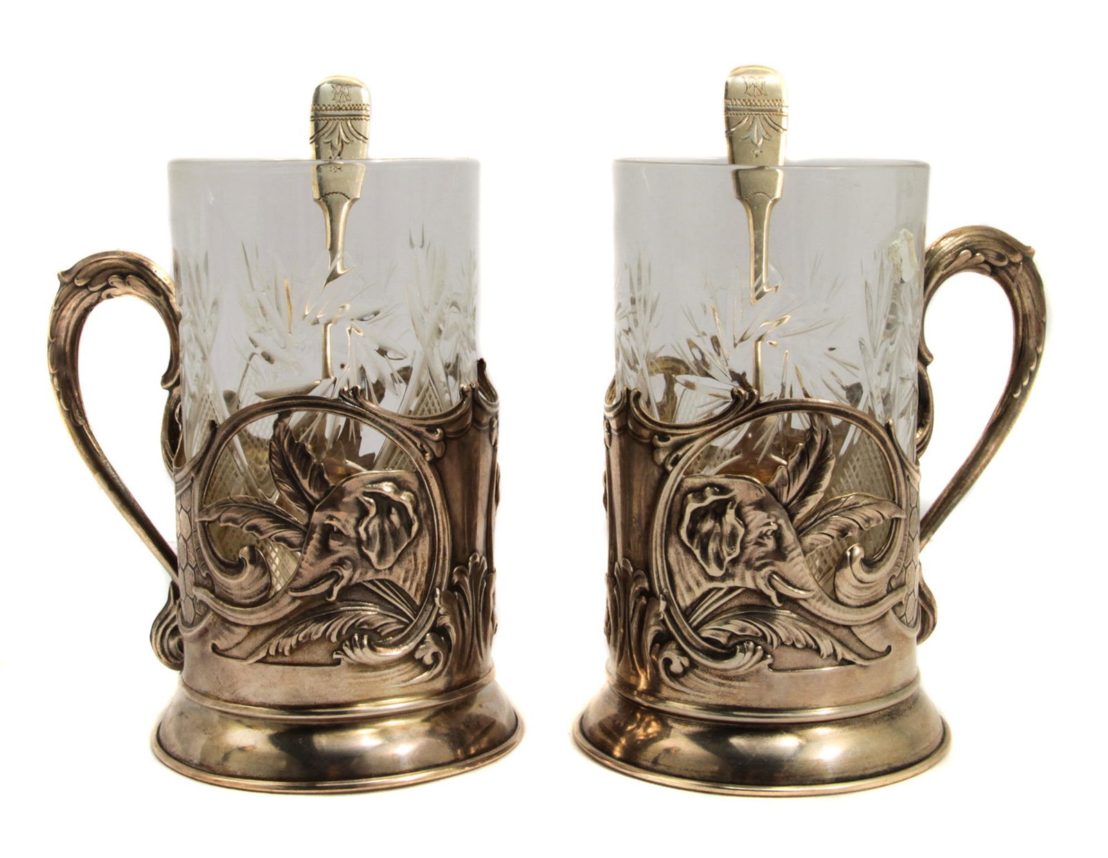 TWO RUSSIAN SILVER ART DECO TEA GLASS HOLDERS: Two early Soviet tea glass holders with Imperial Russian silver engraved spoons.Silver weight: 10.2 oz., 288 g. Dimensions: H: 5 1/8 in., (13 cm.)