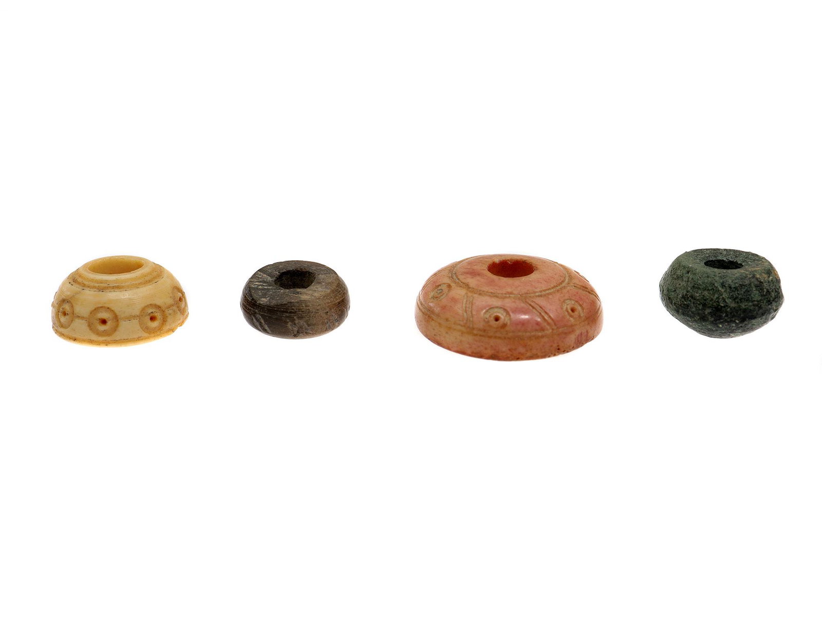 FOUR BACTRIAN SPINDLES, CENTRAL ASIA, 2500 B.C.: Bone and stone spindles of different colors and decorated engravings. Dimensions: Smallest L: 1/2 in., 13 mm.Largest L: 15/16 in., 24 mm.