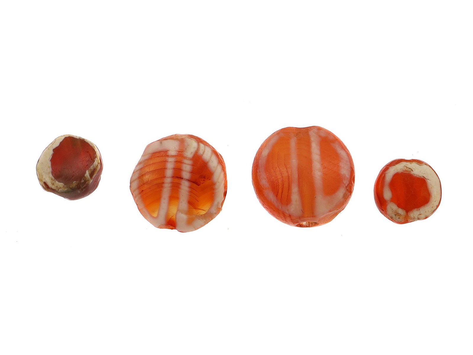 WEST ASIA ETCHED CARNELIAN BEADS, 2500 B.C.: Two pairs of circular etched carnelian beads. Each pair is decorated differently. Could also be found in Central Asia countries. Dimensions: Smallest Diameter: 3/16 in., 5 mm.Largest Diameter: 5/16 in