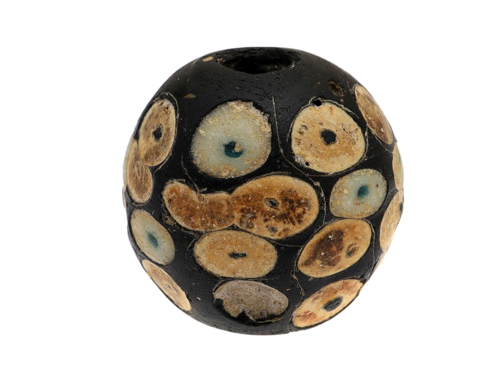 A LARGE PRE-ISLAMIC GLASS EYE BEAD, CA. 610 A.D.: A large Pre-Islamic glass bead featuring a pattern of many eyes across the surface. Dimensions: L: 3/4 in., 18 mm.