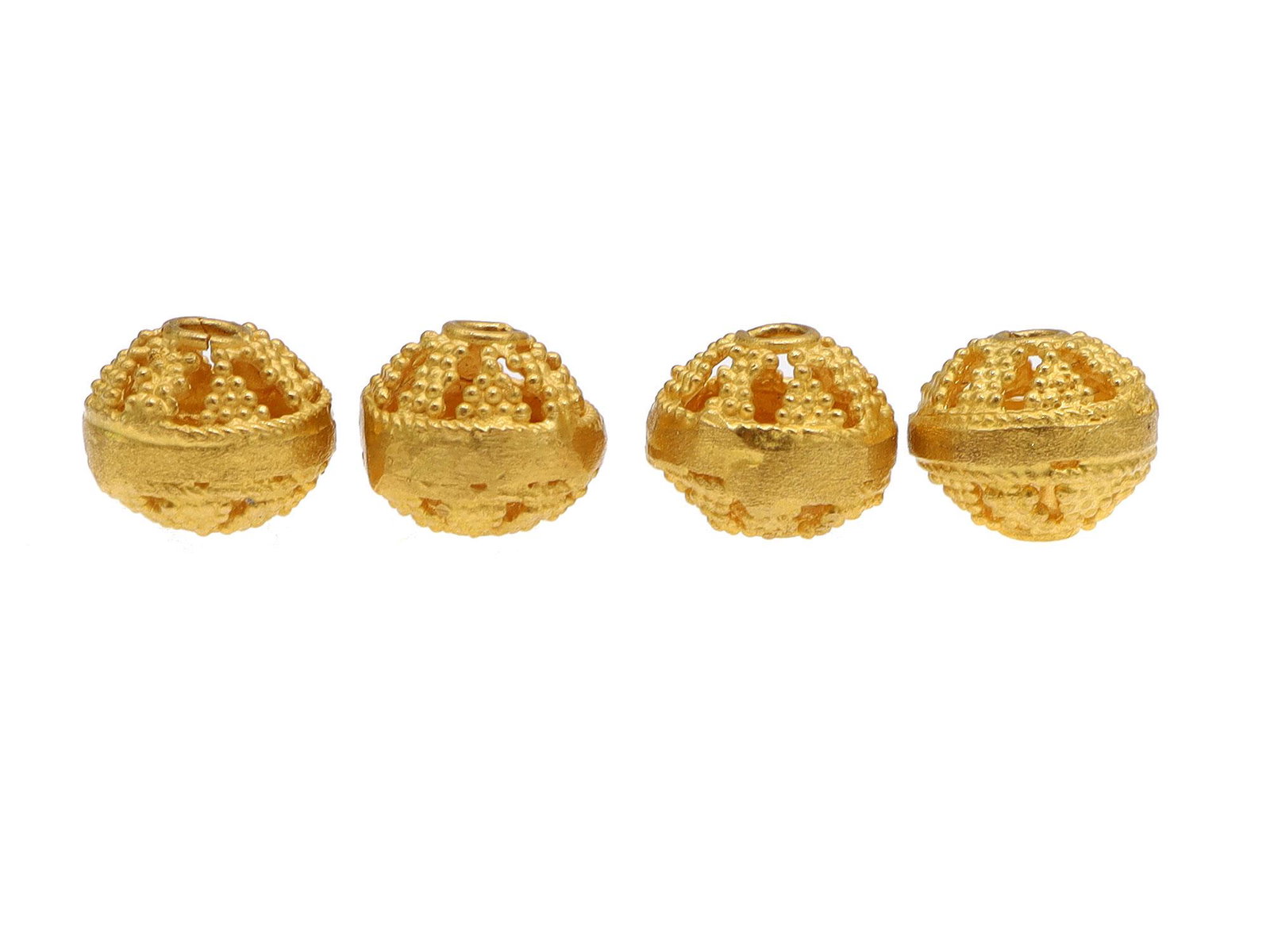 FOUR 18 KARAT GOLD BEADS: An 18 karat decorated gold spacer.Weight: 0.0970 oz., 2.75 gr. Dimensions: 7mm.