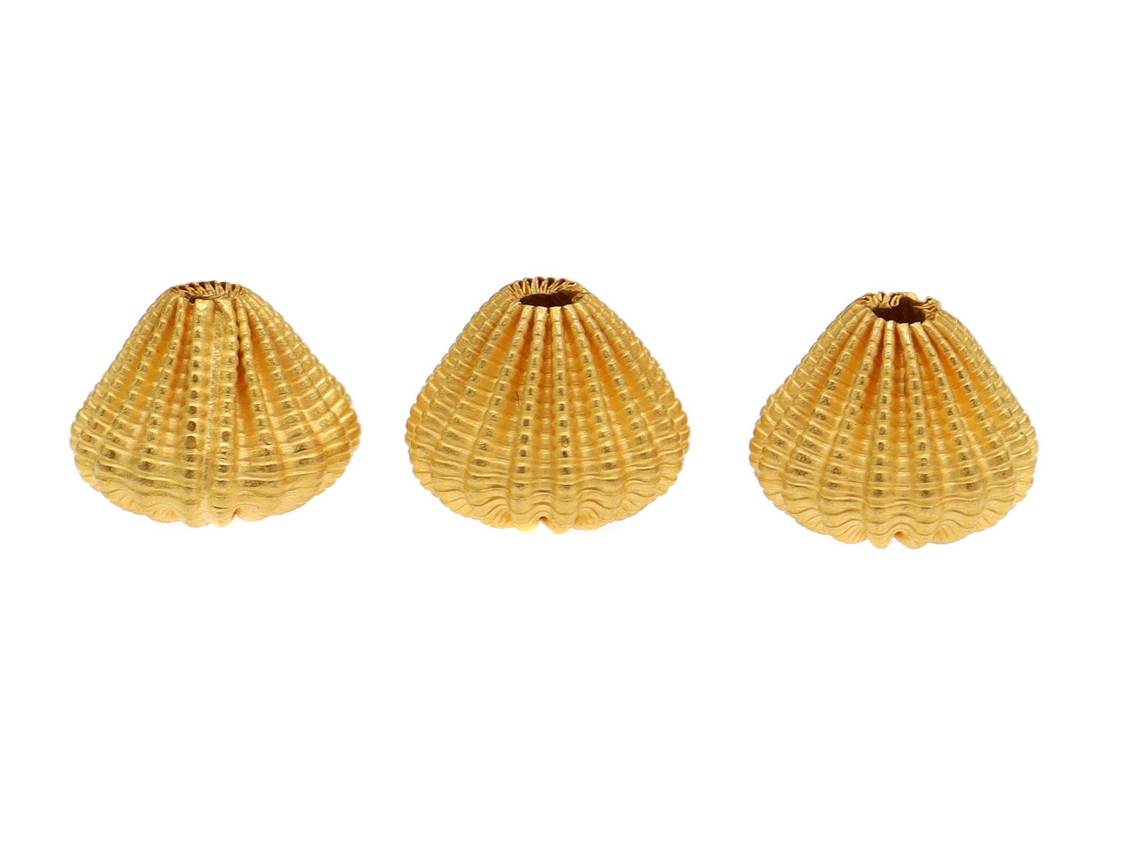 THREE 18 KARAT GOLD BEADS: An 18 karat decorated hollow gold spacer.Weight: 0.0638 oz., 1.81 gr. Dimensions: 7mm.