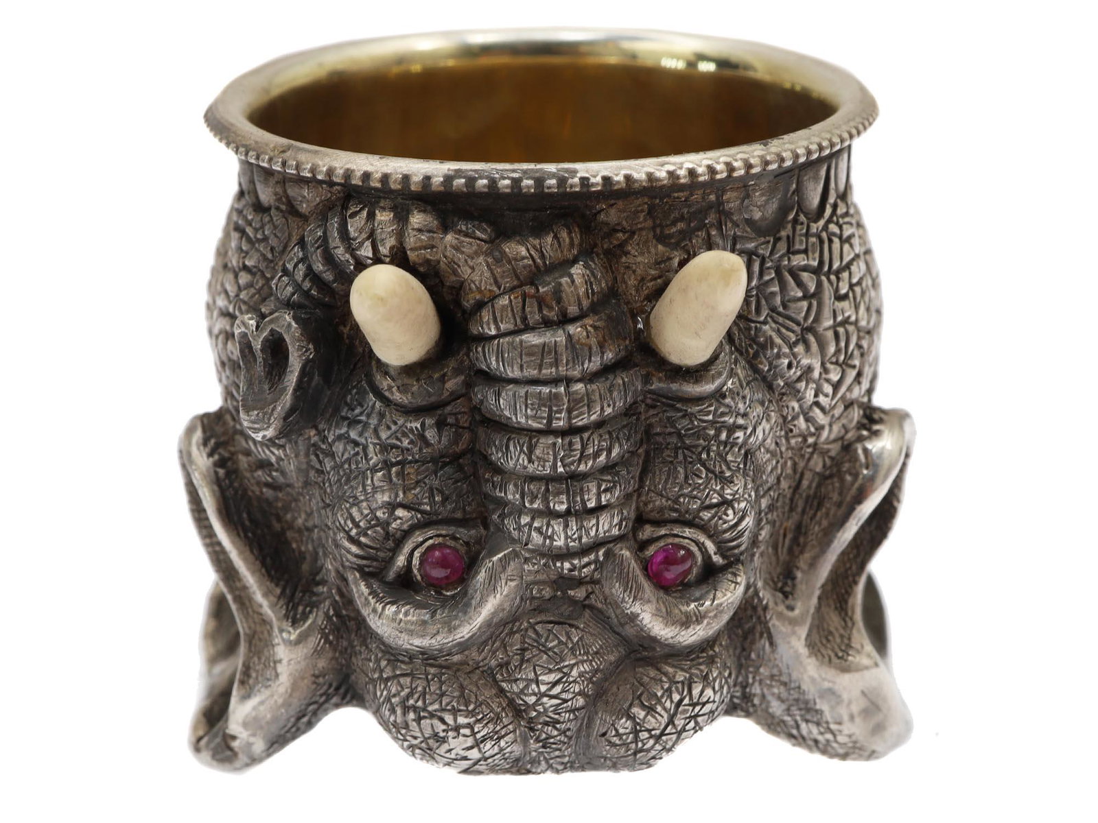 A RUSSIAN GILT SILVER ELEPHANT HEAD STIRRUP CUP: A Russian gilt-silver elephant head stirrup cup. The elephant's tusks are naturalistically made of bone and eyes are decorated with crimson faceted stones. Hallmarks: 88 silver standard next to a woma