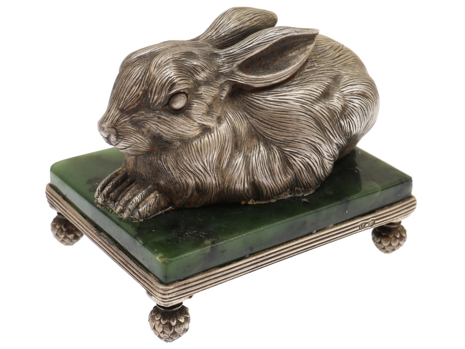 A RUSSIAN SILVER RABBIT ON A JADE LEGGED BASE: A neatly executed Russian silver figurine of a bunny rabbit on a rectangular jade stand in a silver frame with artichoke-shaped legs. Hallmarks: 84 silver standard, the master name stamp with the init