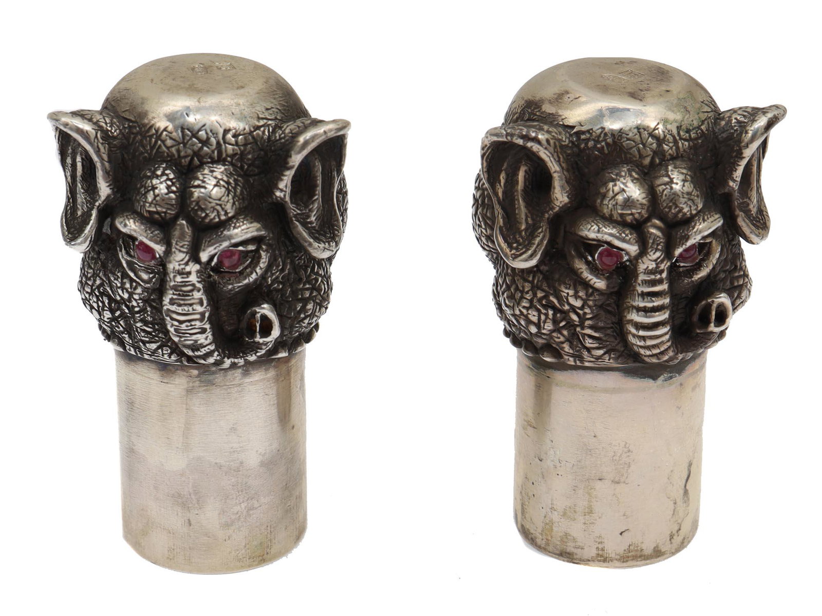 A PAIR OF RUSSIAN SILVER STIRRUP ELEPHANT CUPS: A pair of Russian silver elephant head stirrup cups. The elephants eyes are decorated with crimson faceted stones. Hallmarks: 88 silver standard next to a woman's head in a kokoshnik, turned to the le