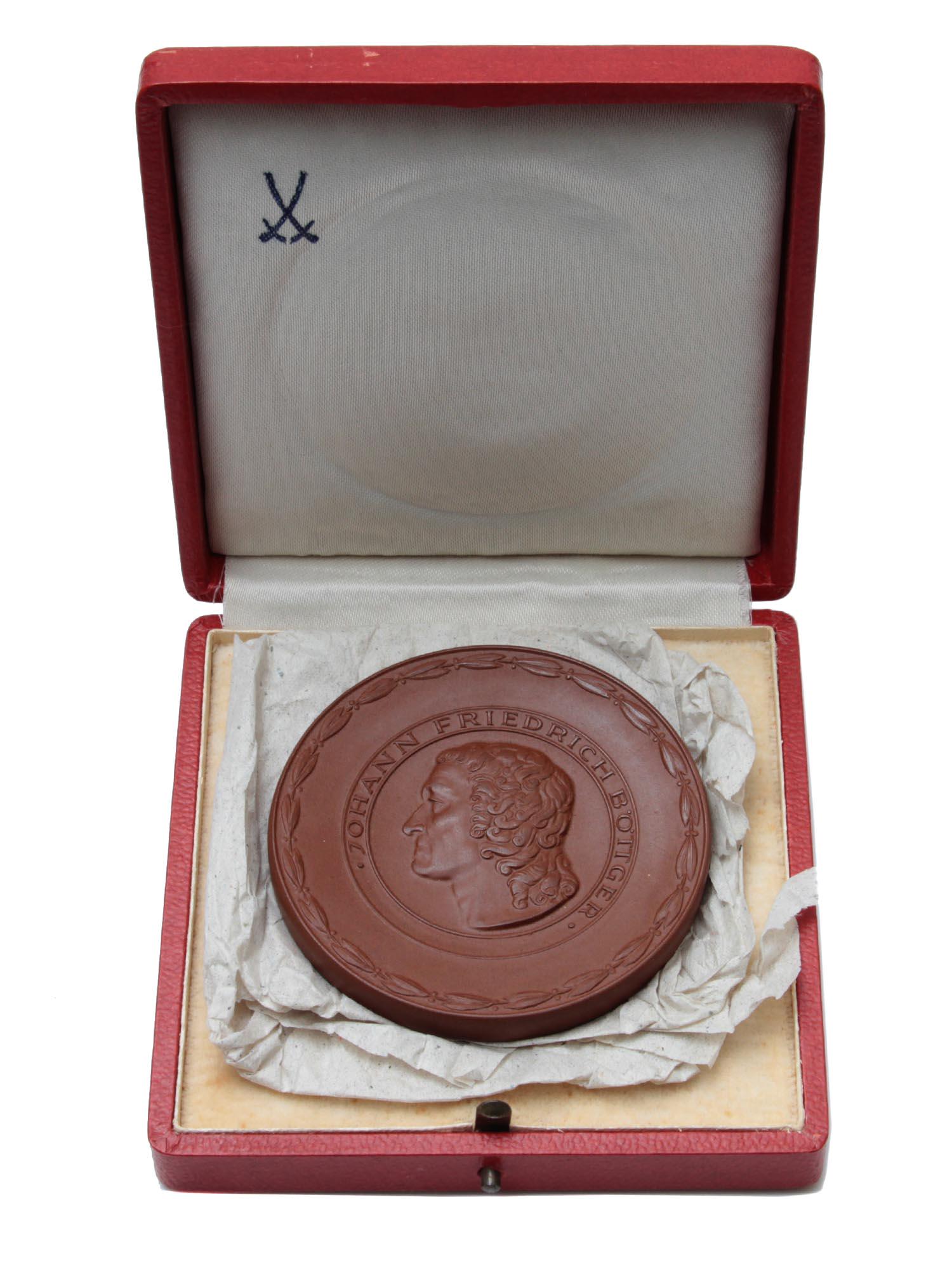 A J. BOTTGER MEISSEN PORCELAIN MEMORIAL MEDALLION: A Johann Bottger Meissen porcelain memorial medallion, made in Germany in 1969, with the original red case.Johann Friedrich Bottger 1682-1719 German alchemist and the first naturalist obtained Europea