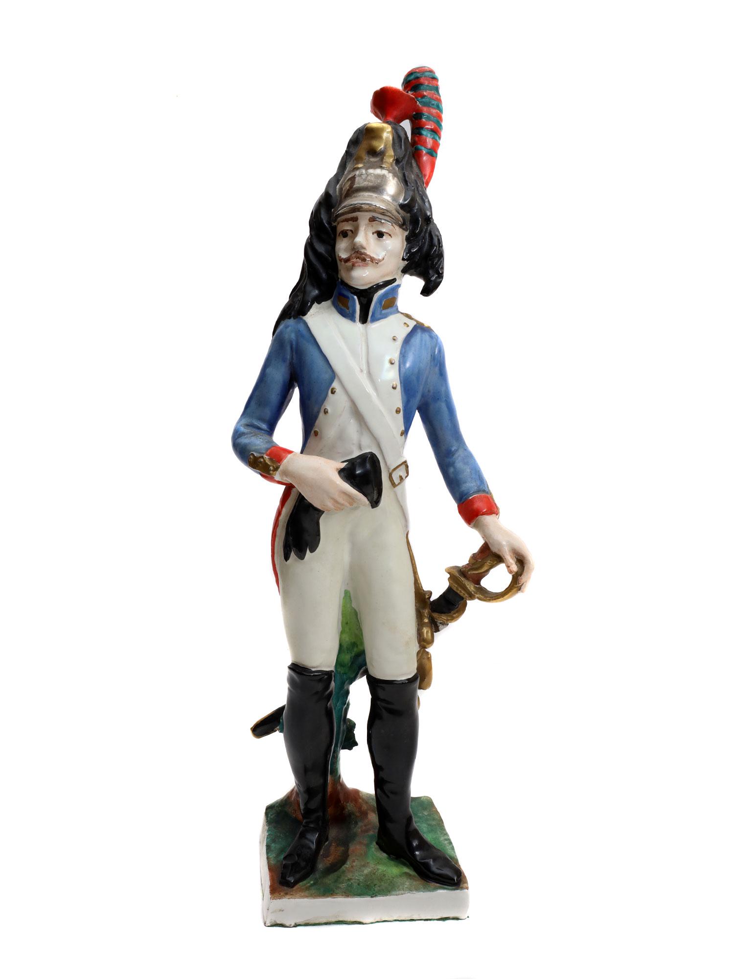 AN ANTIQUE DRESSEL & KISTER PORCELAIN FIGURINE: An antique Dressel & Kister hand-painted porcelain mounted figurine of Curasier of Napoleon's army in a blue military uniform, with a sword, and a black glove in the hand. Made in Germany, stamped on 