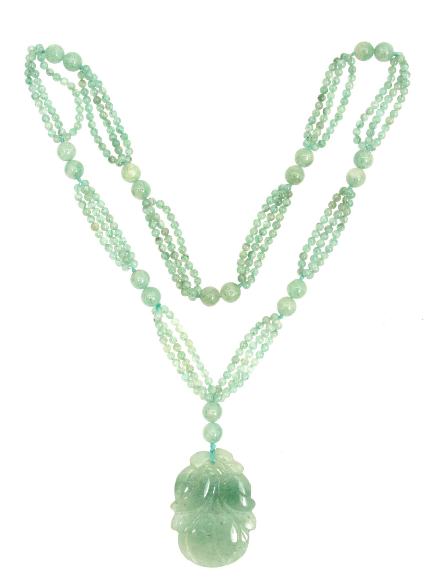 A VINTAGE CHINESE PALE GREEN JADE NECKLACE: A beautiful vintage necklace made of pale green jadeite. Threads with small round beads are held together by larger beads; in the center, there is a pendant in a well-carved fruit and leaf form. Dimen