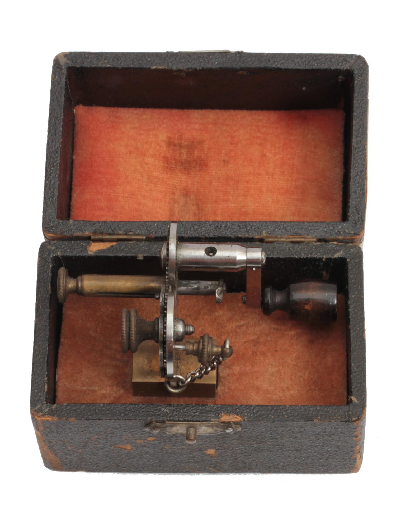 A VINTAGE WATCHMAKER'S BOW PIVOTING TOOL: Marked "D.R.G.M. / â„–14658." Completed with a vintage wooden box. Germany, circa early 20th-century. Dimensions: Machine: 2 1/4 x 2 1/8 in.Box: 3 1/2 x 2 1/8 x 2 5/8 in.