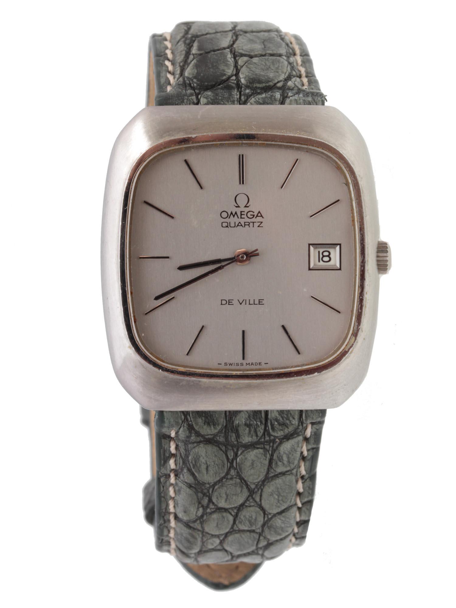 A VINTAGE OMEGA MEN'S WRIST WATCH: An elegant Omega De Ville men's watch. This item features a green genuine alligator leather strap with silver-toned quartz bezel. Dimensions: Bezel: 1 1/4 x 1 1/8 in. D: 2 5/8 in. Approximately.