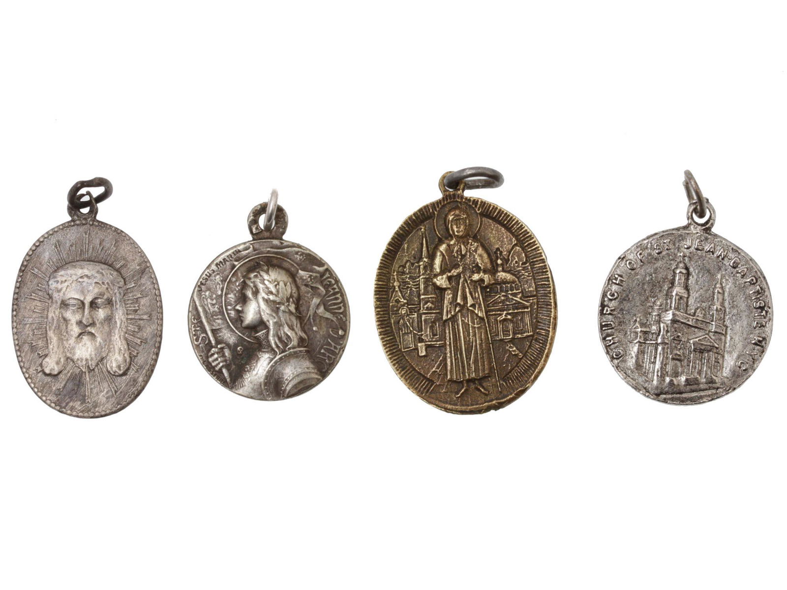 A SET OF FOUR RUSSIAN ANTIQUE CHRISTIAN PENDANTS: The lot includes:1. A vintage oval silver-tone pendant, the obverse depicts the head of Jesus Christ in the rays of light, the reverse is engraved with an inscription in Russian, Bless and Save.2. An
