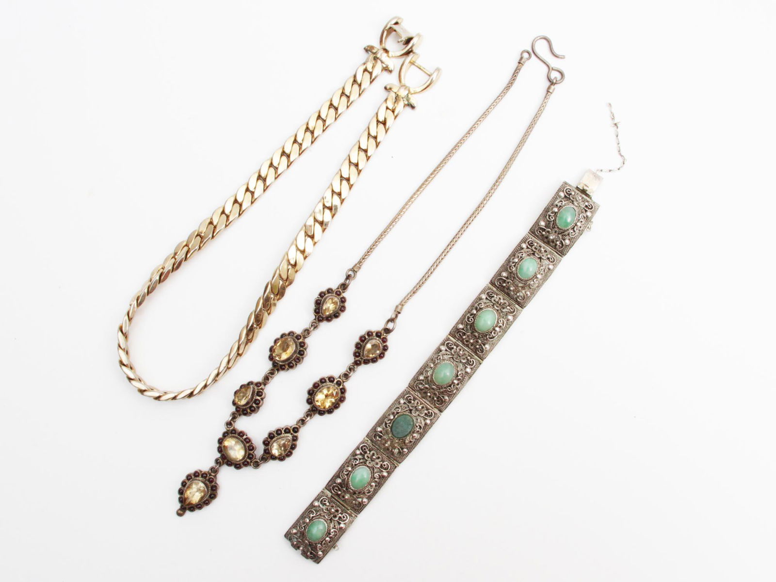 A SET OF VINTAGE AND ANTIQUE SILVER JEWELRY: The set includes: A gold-plated heavy choker by Coro Pegasus (stamped on a clasp), a necklace in 925 sterling silver with cut citrine inlays surrounded by garnet cabochons, and a silver bracelet decor