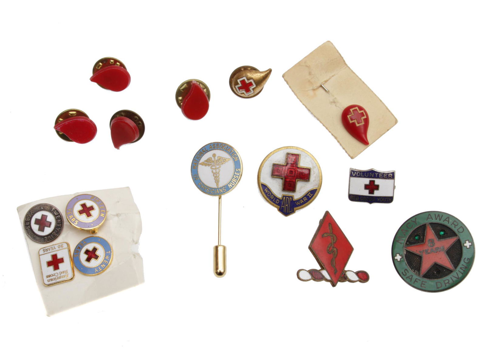 A LOT OF 15 VARIOUS AMERICAN RED CROSS PINS: Lot includes 14 American Red Cross pins, including a WWII ARC (American Red Cross) service pin, 6 blood donor pins, various Red Cross volunteer pins, and a MACY Award for safe driving. Dimensions: Sma