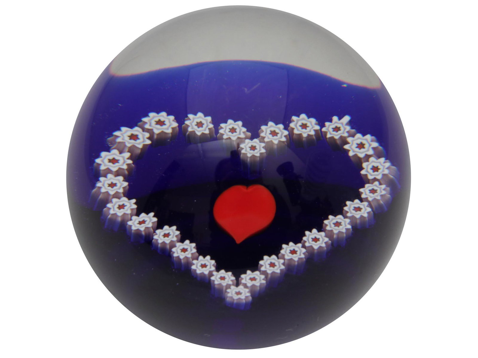 A CAITHNESS ART GLASS PAPERWEIGHT SCOTLAND: A vintage collectible art glass paperweight by Caithness, Scotland. The paperweight interior design is made with a red heart and heart-shaped flowers around it, located on a blue base. Signed on the b