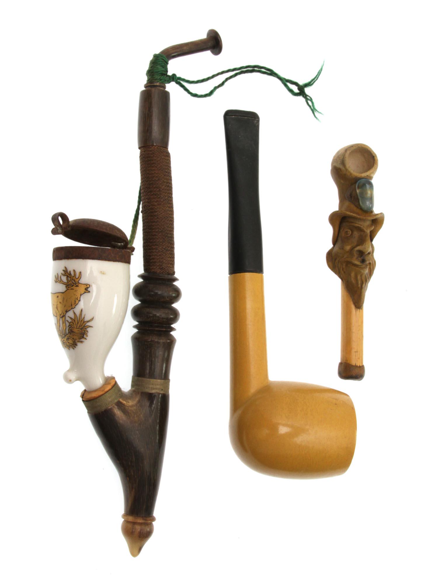 A LOT OF THREE ANTIQUE SMOKING PIPE: A lot of three smoking pipes. First made of wood with ceramic Stummel, painted with moose, with metal lid. Second, made of wood with an ebony mouthpiece. Third smoking pipe made from carved wood and s