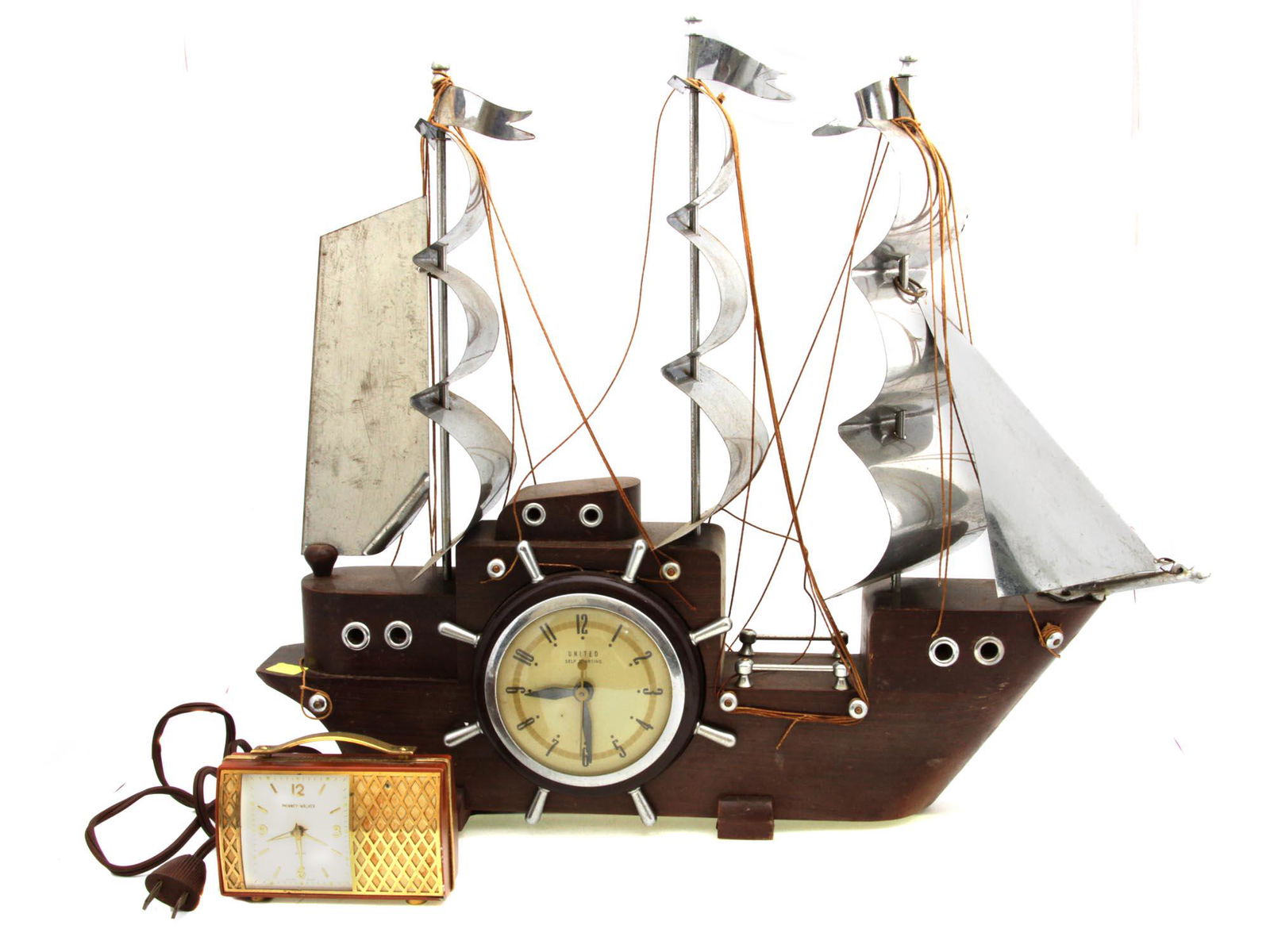 A LOT OF TWO VINTAGE MANTEL CLOCKS: The lot includes two vintage mid-century clocks: a vintage United Electric self-starting clock in the form of a ship and a Swiss-made musical alarm clock by Phinney Walker. Dimensions: Smaller: 4 x 2