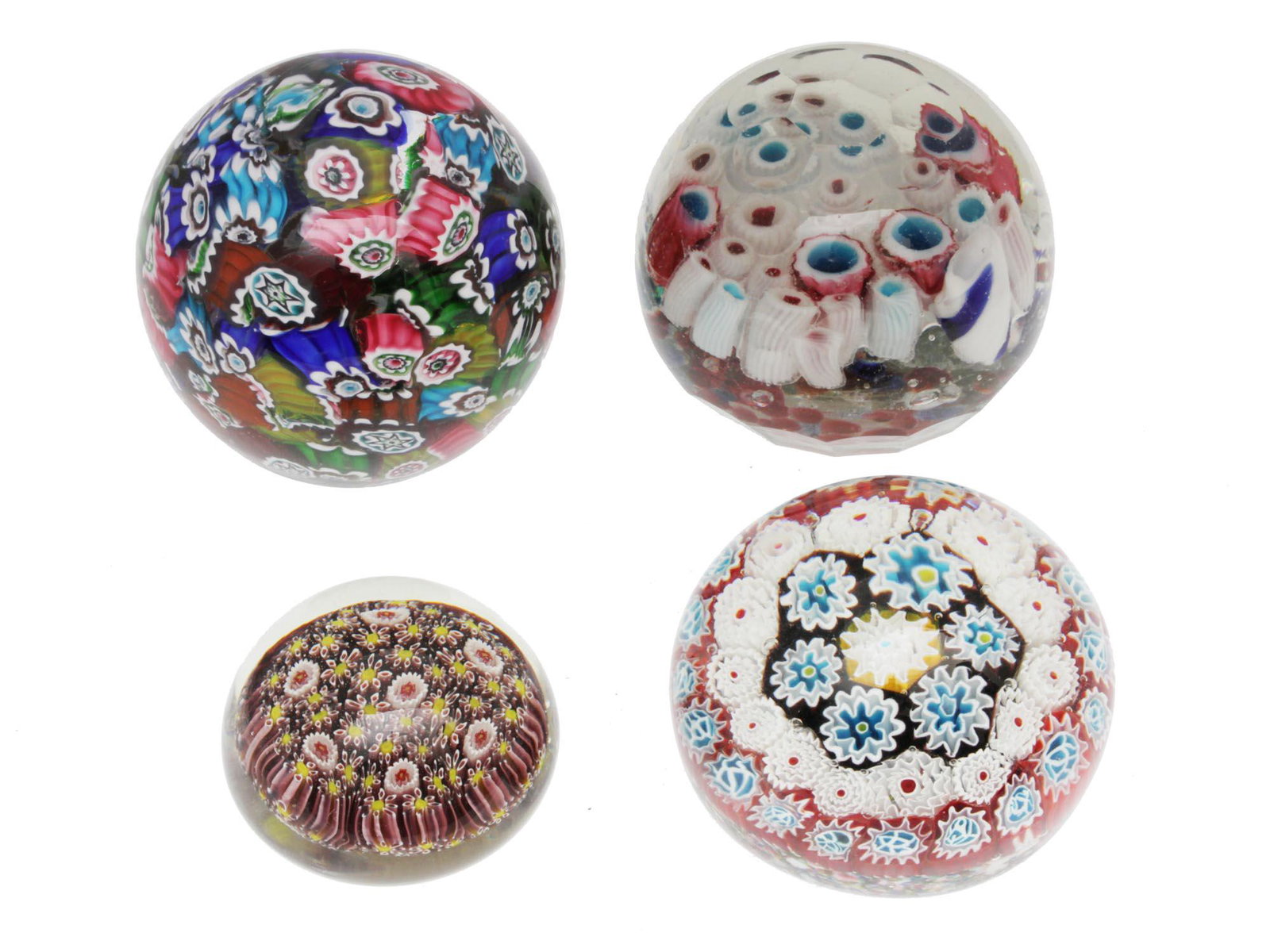 A SET OF FOUR VINTAGE ART GLASS PAPERWEIGHTS: A set of four vintage Baccarat style unmarked art glass paperweights decorated inside with various colorful floral patterns inspired by nature. Dimensions: Smallest D: 2 1/4 in. Largest D: 3 1/8 in.