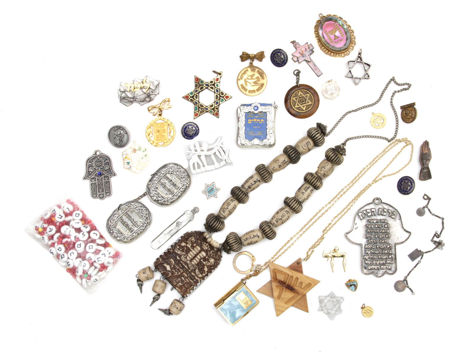 A LOT OF VINTAGE JEWISH CUSTOM JEWELRY JUDAICA: A set of various jewelry with Jewish symbols. Includes brooches, beads, pendants, bracelets, and key rings. Also in a separate bag is a set of colored beads and white beads with black Hebrew letters f