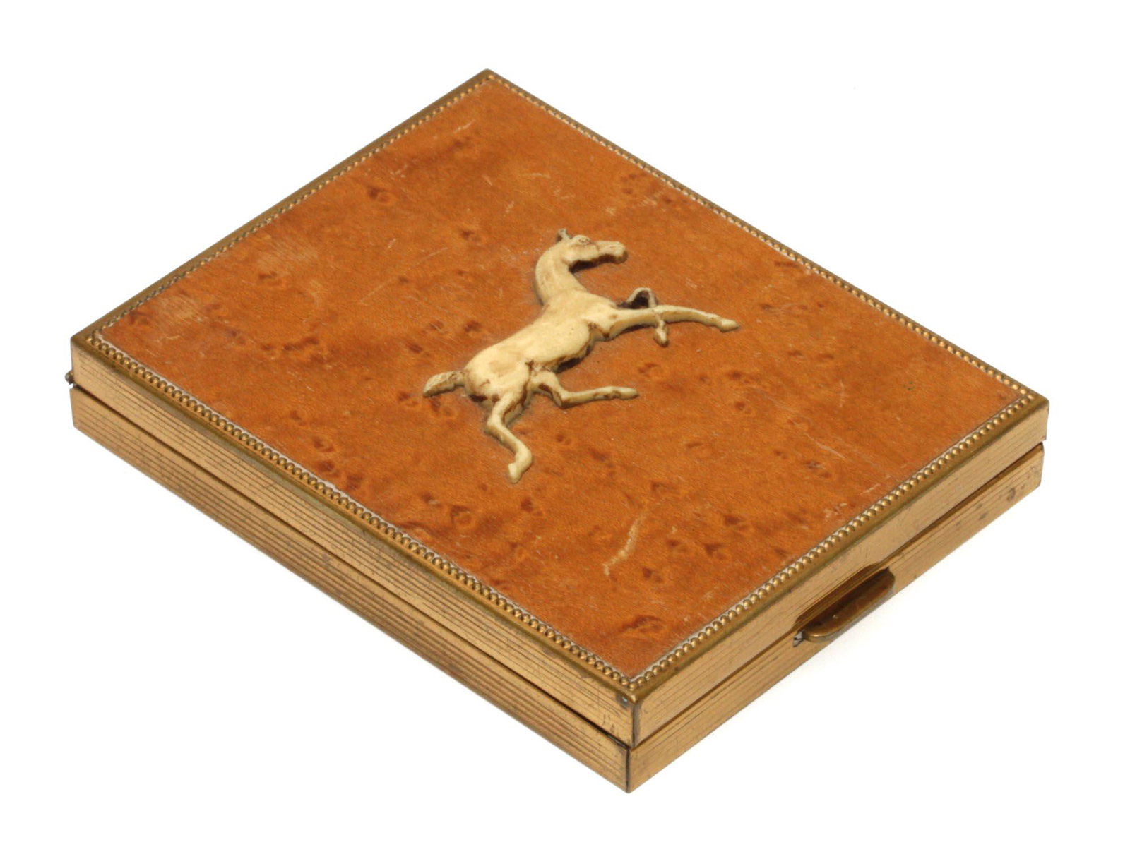 AN ANTIQUE RUSSIAN BIRCH WOOD CIGARETTE CASE: An early 20th-century Russian cigarette case made of birch wood with brass fittings. The lid is decorated with a brass plate in the shape of a horse. Dimensions: 3 3/4 x 3 in.
