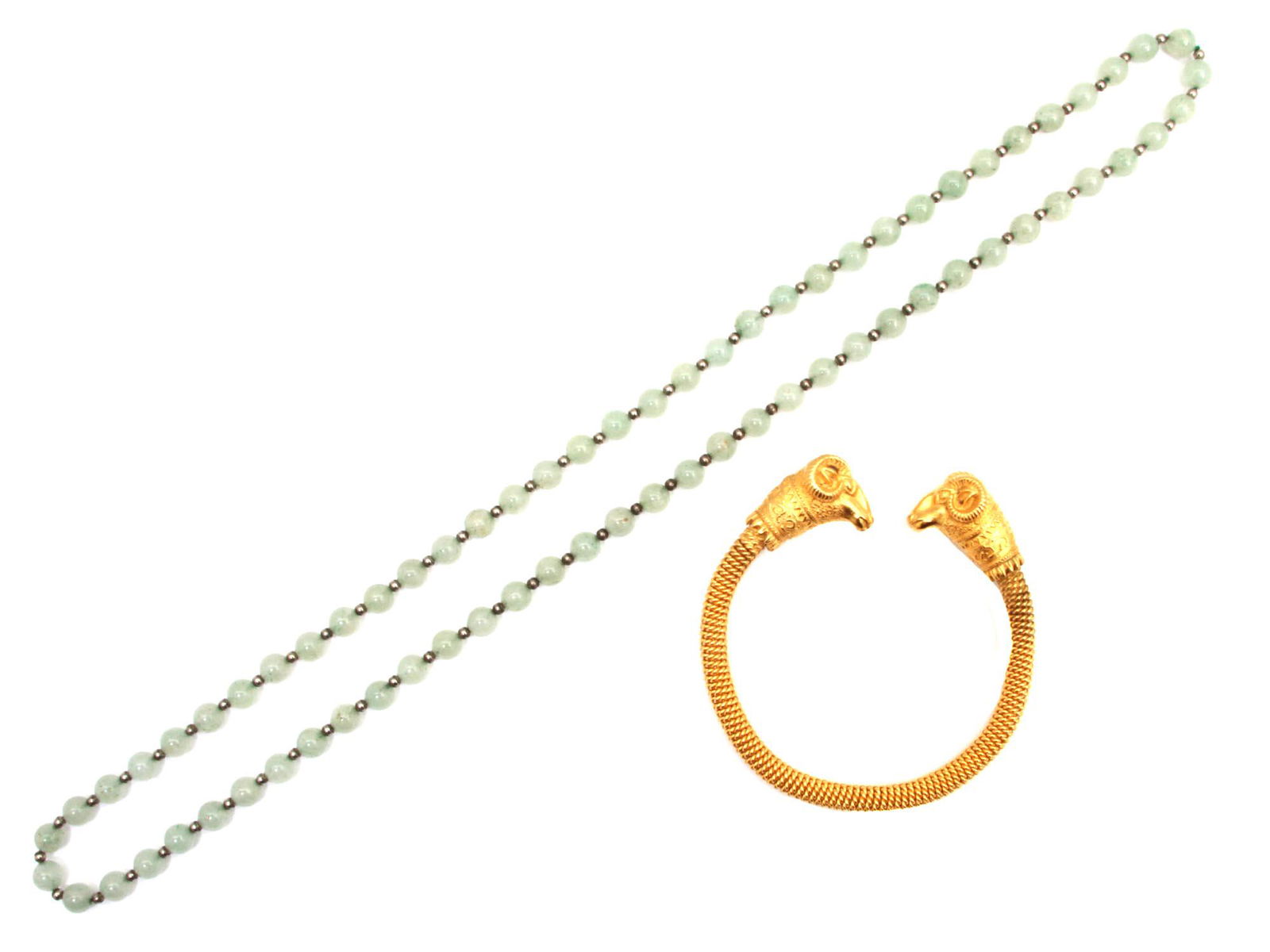 A GILT METAL BRACELET AND A JADE NECKLACE: An elegant vintage jewelry set. A beautiful gilt metal bangle bracelet decorated with double ram's head and a long necklace with natural jade beads interspersed with small silver beads. Dimensions: Ne