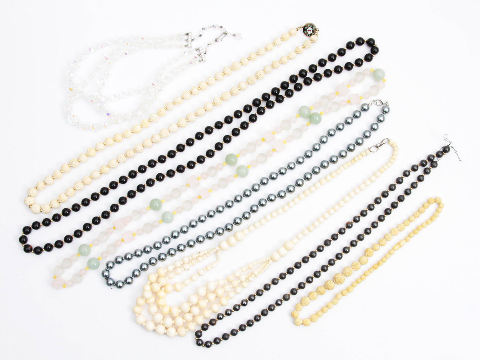 A VINTAGE JEWELRY NECKLACE JADE LAGUNA: A lot of eight vintage jewelry items. Included: Crystal necklace marked by Laguna, Hematite necklace, Carved bone necklace, Carved bone necklace with enameled metal clasp, Bone layered necklace, Jade