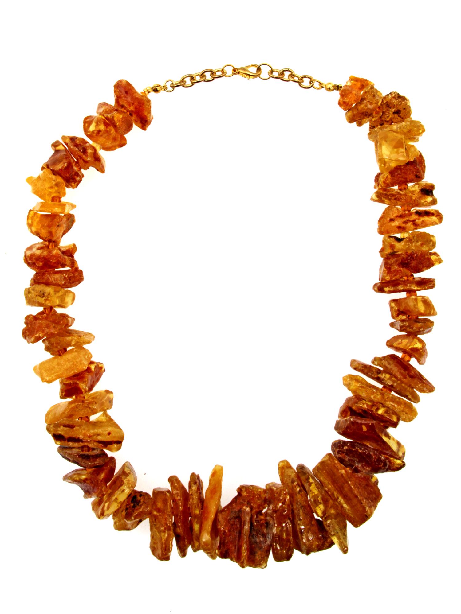 A VINTAGE JEWELRY AMBER NECKLACE: A vintage custom jewelry massive necklace made of unpolished pieces of Baltic amber of various sizes and transparency. Weight: 103 g. Dimensions: L: 19 in.