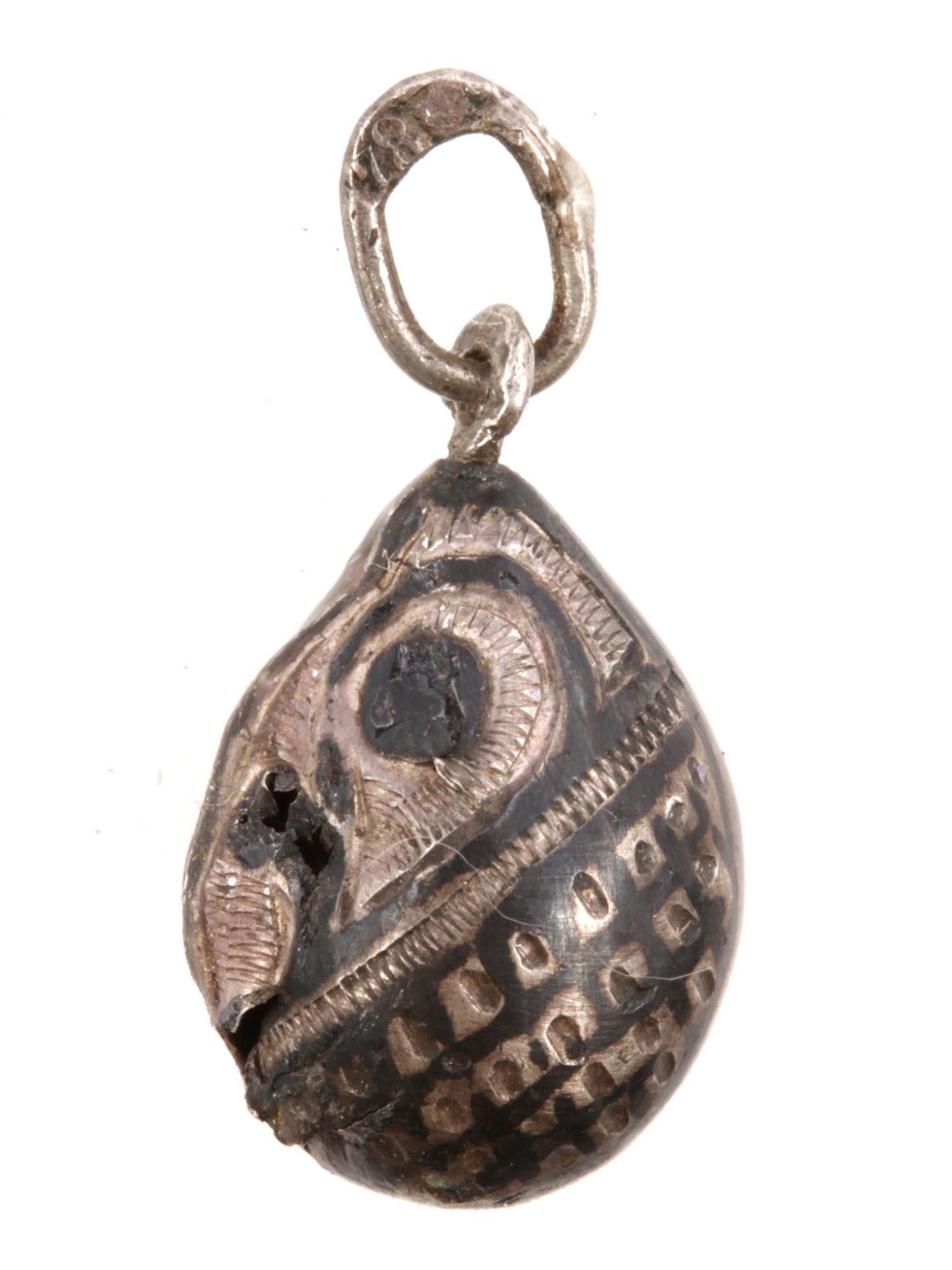 AN ANTIQUE RUSSIAN SILVER AND NIELLO EGG PENDANT: An early 20th-century Russian miniature egg pendant made of silver decorated with engraved patterns and blackening. Hallmarked on the loop with an 84 silver standard stamp. Weight: 1 g. Dimensions: H: