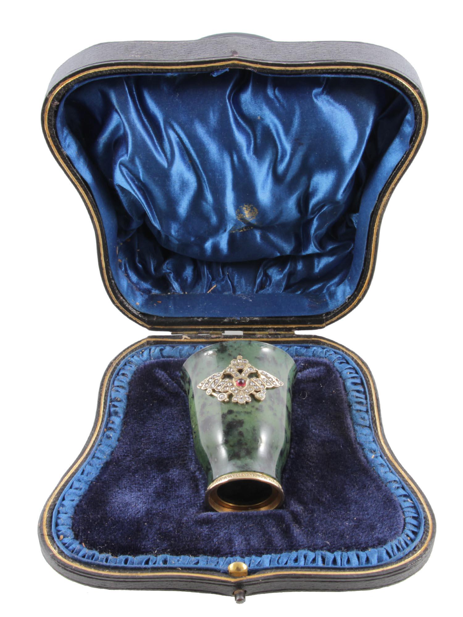 A RUSSIAN JADE CUP WITH A GOLD SETTING: A Russian cup, carved from green jade with a gold setting at the base and a gold overlay in the form of a relief double-headed eagle, inlaid with diamonds and a ruby cabochon. Hallmarks: 56 gold stand
