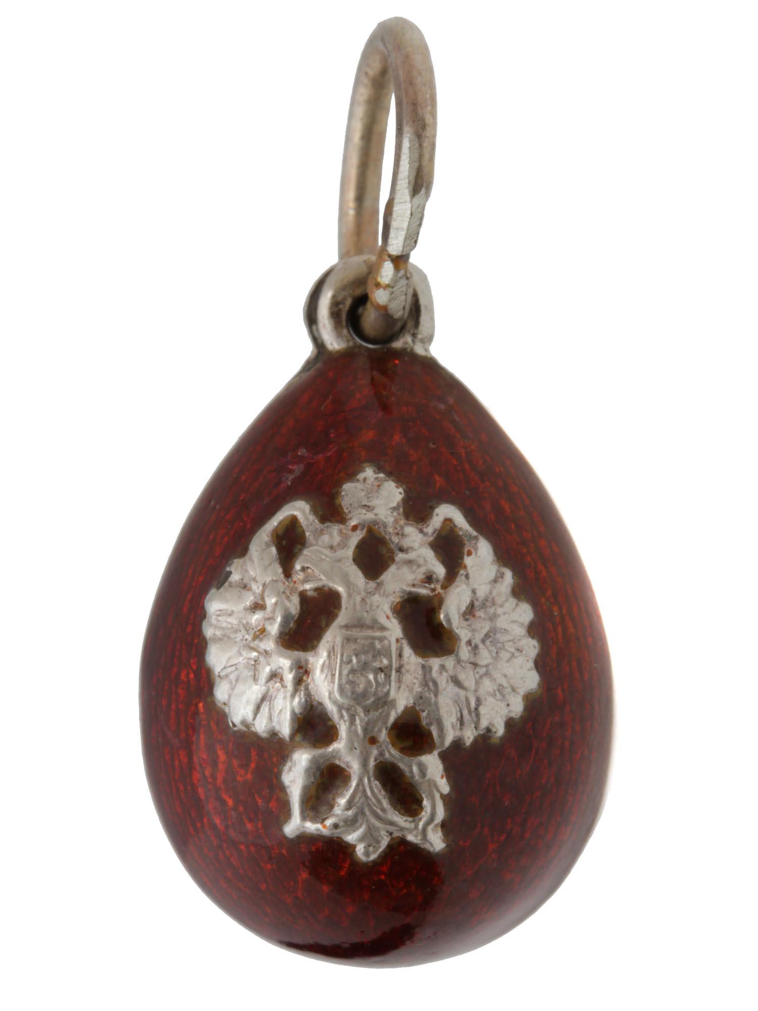 A RUSSIAN SILVER AND ENAMEL EGG PENDANT: A Russian miniature egg pendant made of silver and burgundy guilloche enamel. The central part is decorated with a relief silver double-headed eagle. Hallmarks on the loop: 84 silver Russian standard