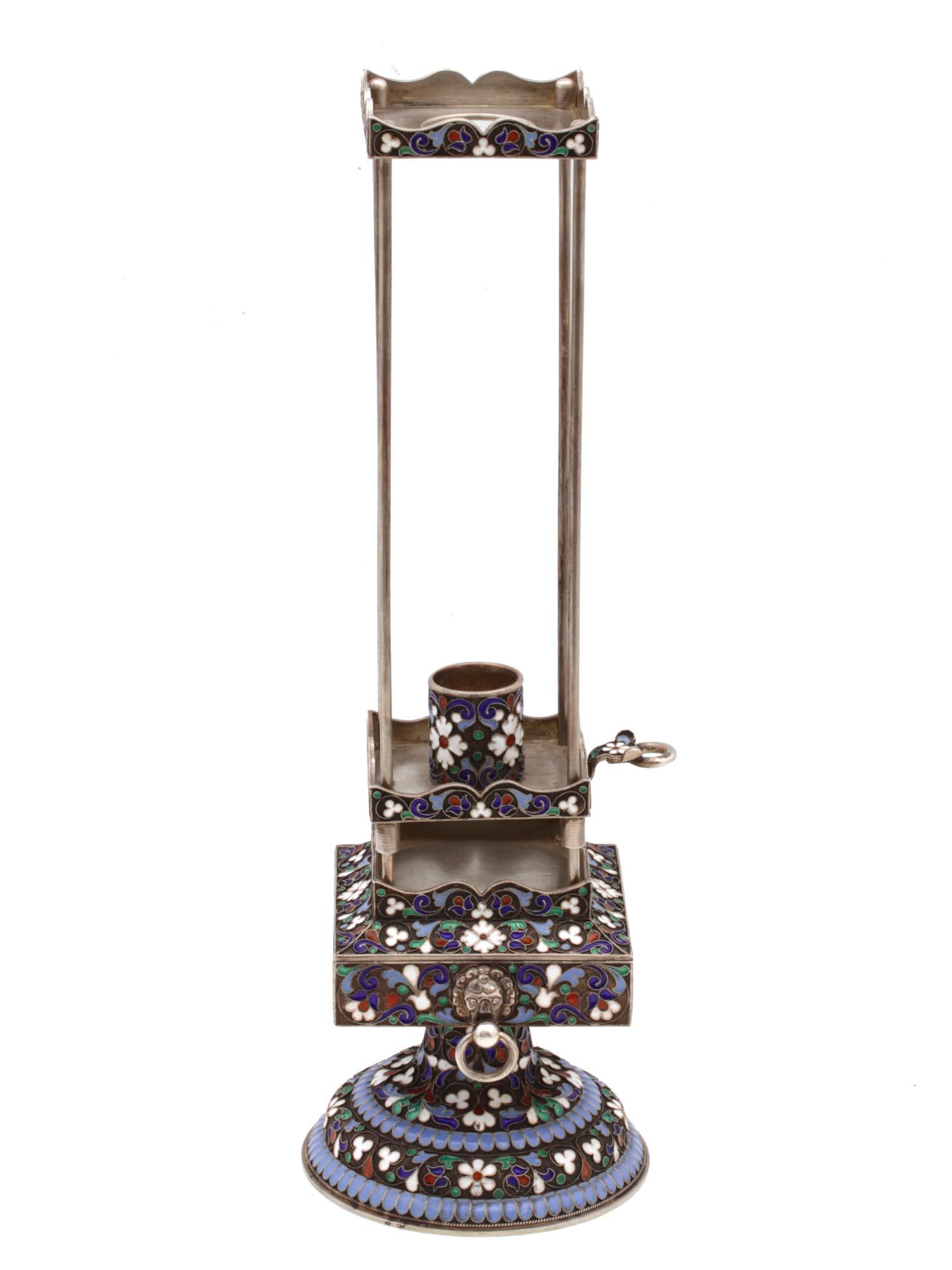 A RUSSIAN JUDAICA SILVER & ENAMEL CANDLE HOLDER: A Russian Judaica candle holder made of silver, richly decorated with polychrome cloisonnÃ© enamel. Hallmarks: 84 silver standard, assay master initials A.C. under the date 1894, and master's initia