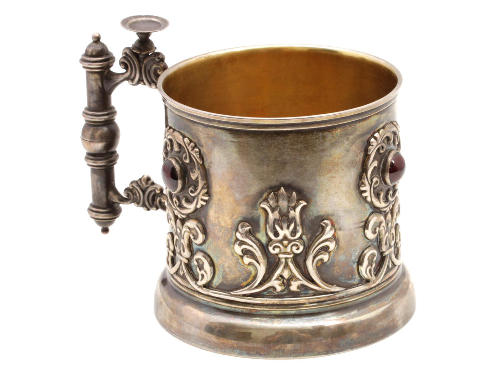 A RUSSIAN SILVER CUP HOLDER WITH GARNETS: A Russian silver cup holder with cast patterns and inlays with three garnet cabochons. Gilded inside. Hallmarks: 88 silver standard next to a woman's head in a kokoshnik, turned to the left, and other
