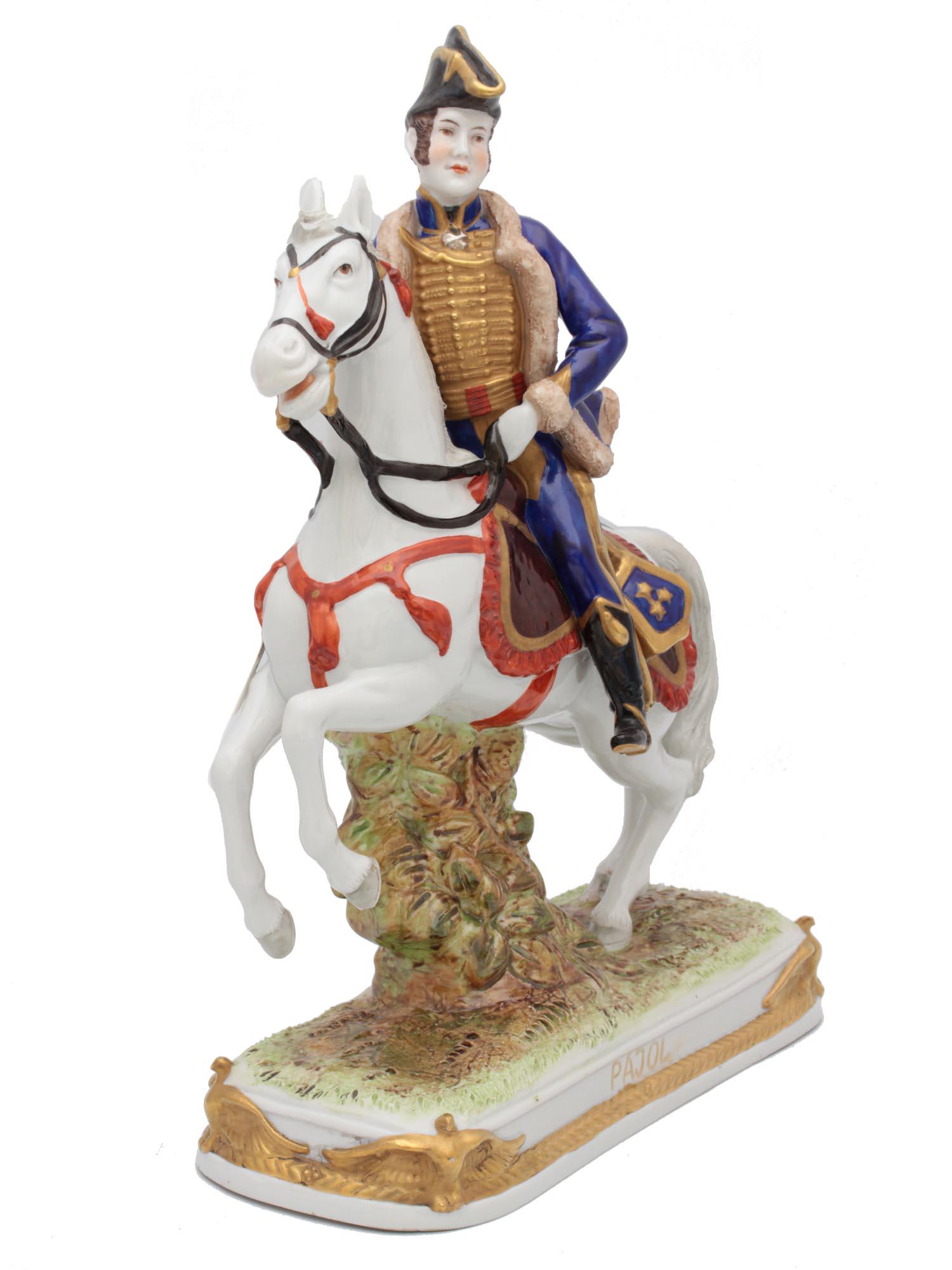 A NAPOLEON MARSHAL PAJOL PORCELAIN FIGURINE: Hand-painted porcelain mounted soldier figurine of Napoleon's Marshal Claude Pajol astride a horse with gilded details and four gilded French Imperial eagles at the edges of the rectangular pedestal, 