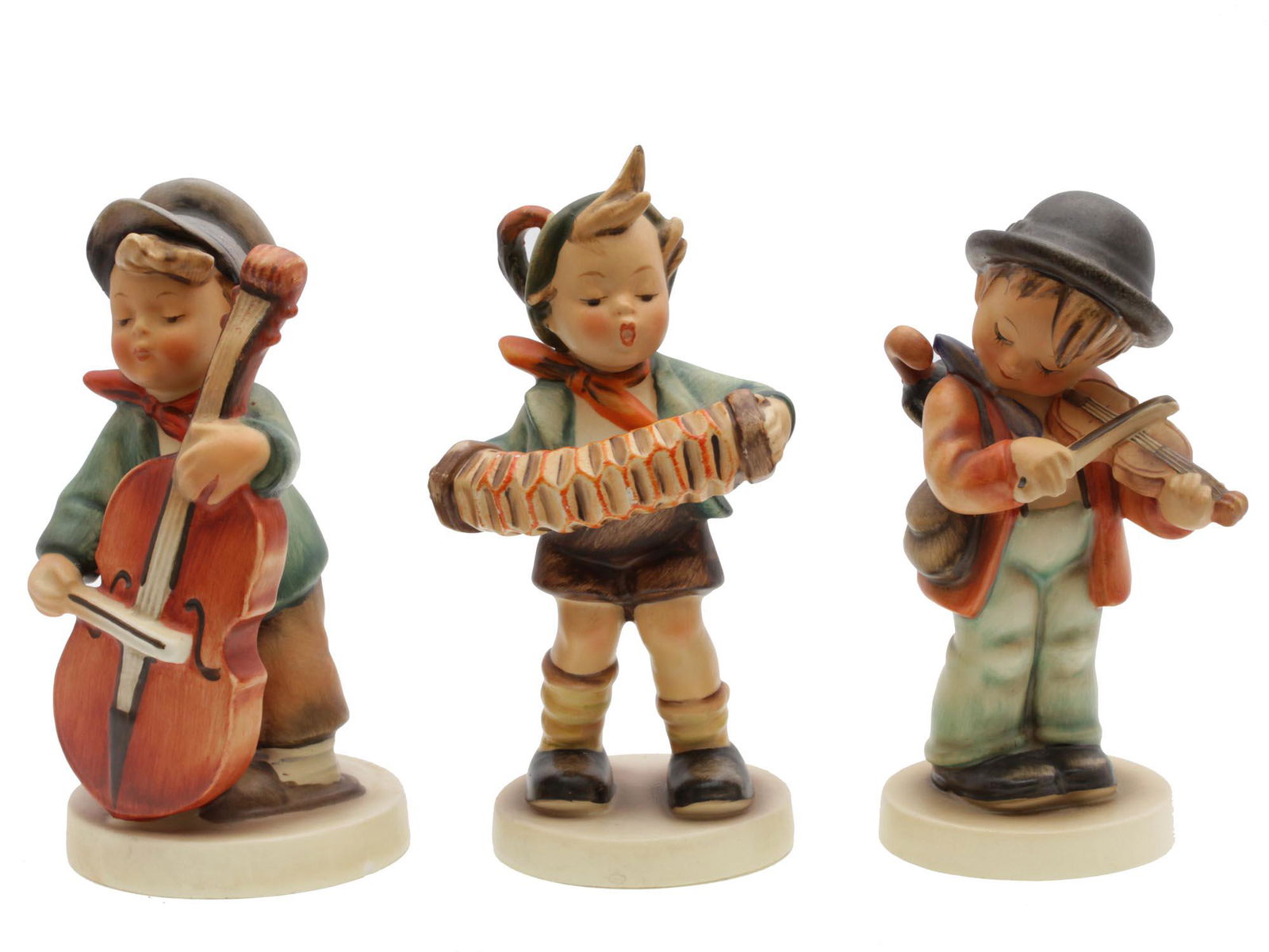 A SET OF VINTAGE HUMMEL GOEBEL PORCELAIN FIGURINE: Three vintage collectible figures depicting boys playing music. All figures are stamped on bases with M.J. Hummel inscription and are marked on the bottom with blue overglaze W. Goebel stamps. Dimensi
