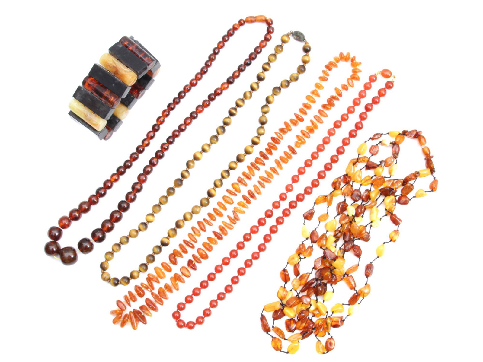 A VINTAGE JEWELRY NECKLACE AMBER SILVER: A lot of vintage jewelry items. Included: three amber necklaces, tigerâ€™s eye bead necklace with marked silver clasp, coral bead necklace by Lucoral, and Bakelite bracelet. Amber weight: 115 g. 