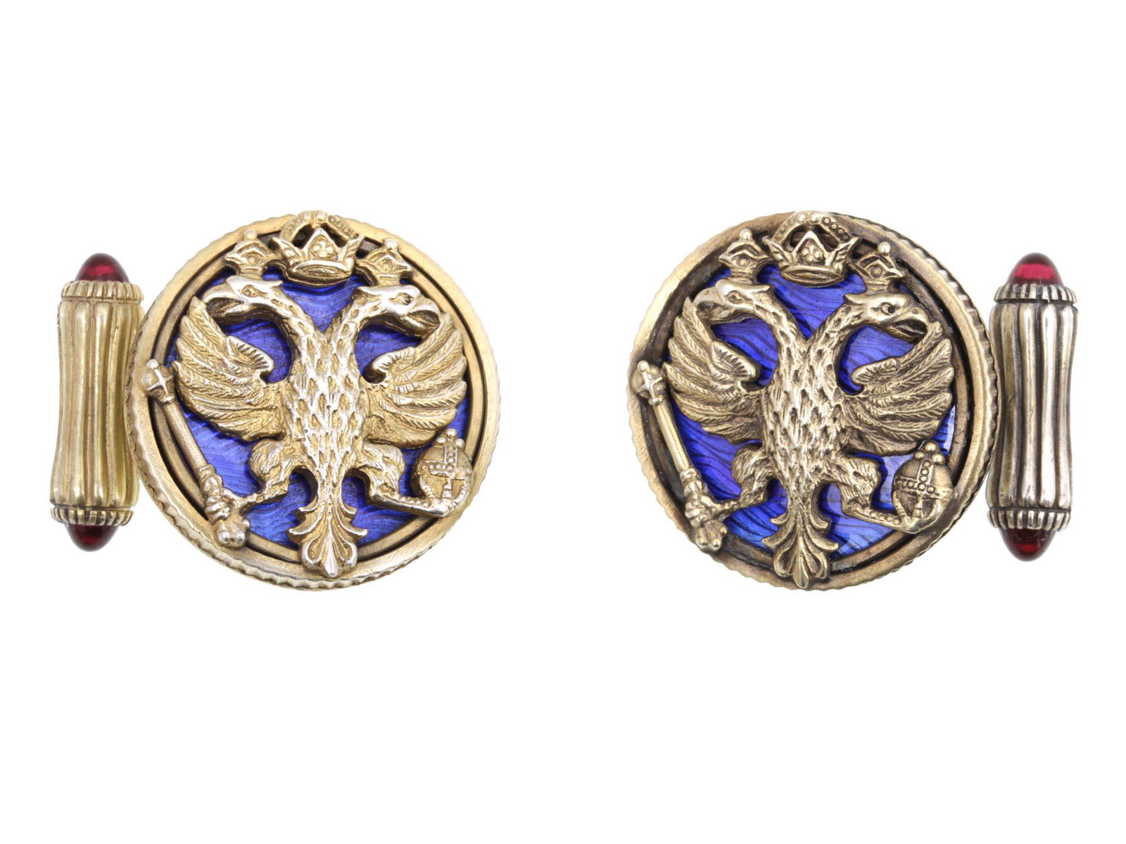 A RUSSIAN GILDED SILVER ENAMEL RUBY CUFFLINKS: A Russian gorgeous gilt-silver cufflinks, decorated with an Imperial two-headed eagle with a crown, orb, and scepter on a blue enamel background, and rubies on the fasteners. Stamped with Russian hall