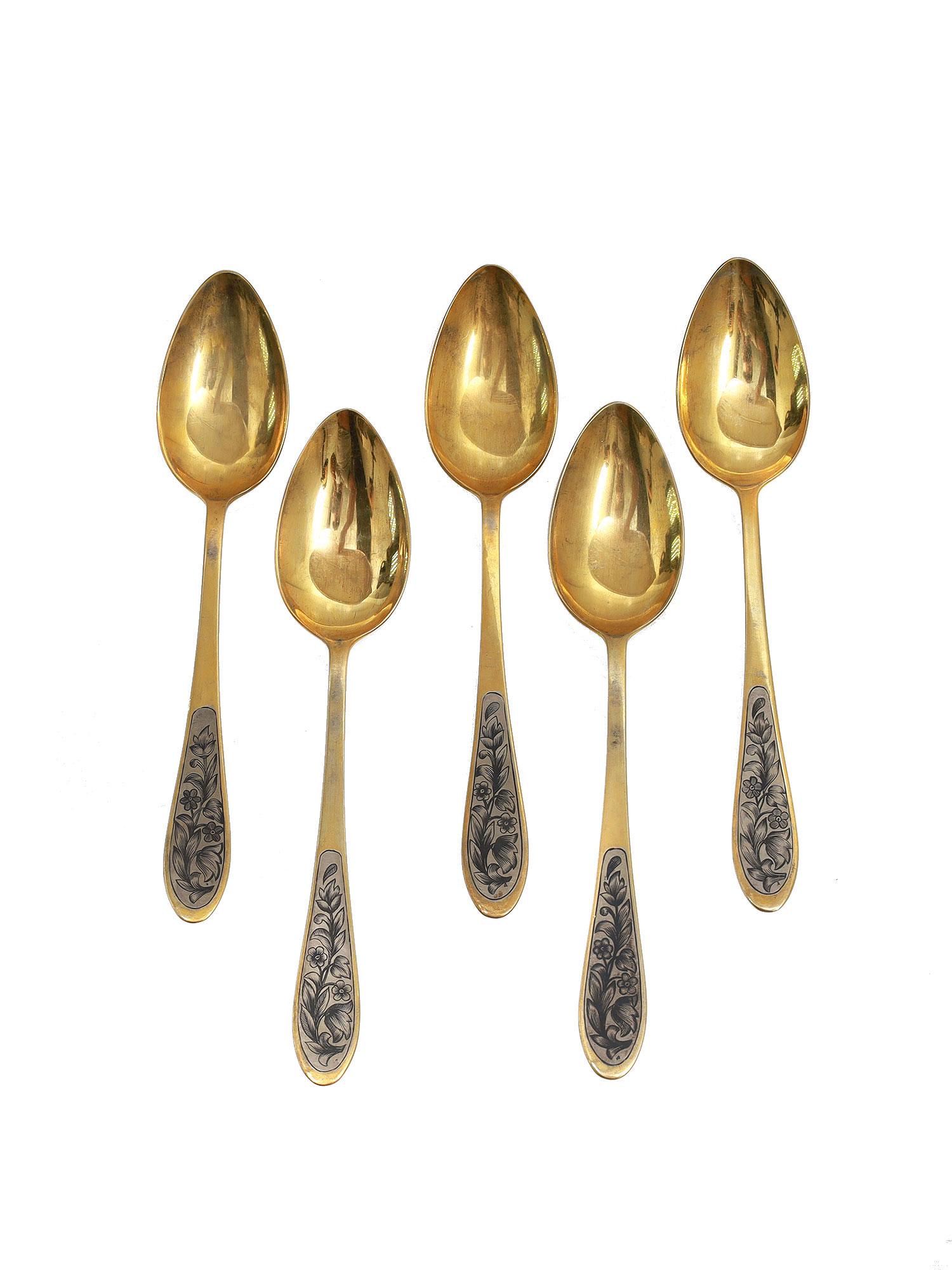 A SET OF FIVE SOVIET GILT SILVER & NIELLO SPOONS: Five Soviet silver soup spoons featuring a niello-finished floral motif. Hallmarked: SCh 8,875 silver standard. Weight: 11.4 oz., 322 g. Dimensions: 8 1/4 in. (21 cm.)