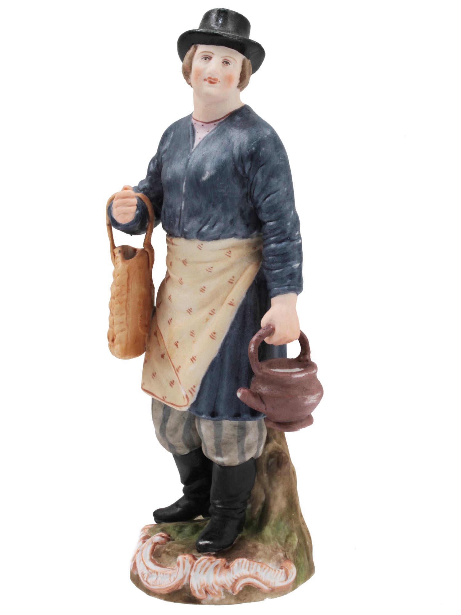 A RUSSIAN GARDNER PORCELAIN FIGURINE LATE 19TH C: An antique porcelain figurine of a tea vendor from the Gardner factory. Depicts a man wearing a hat, a long coat, and an apron. On one hand, he has a wicker bag, and in the other, he holds a kettle. T