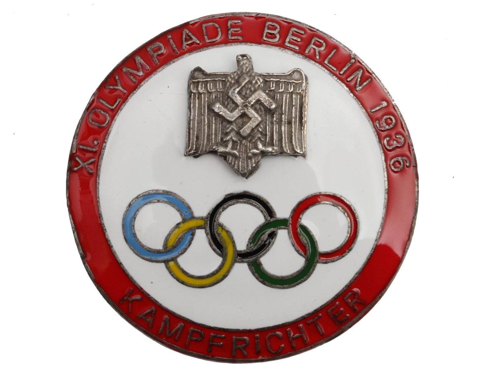 A 1936 GERMAN BERLIN OLYMPIC KAMPFRICHTER BADGE: A German Berlin 1936 Olympic Games Richter Kampfrichter badge. The badge obverse with a Nazi swastika rune is enameled in white color, with five Olympic rings and a red enameled border with an inscrip