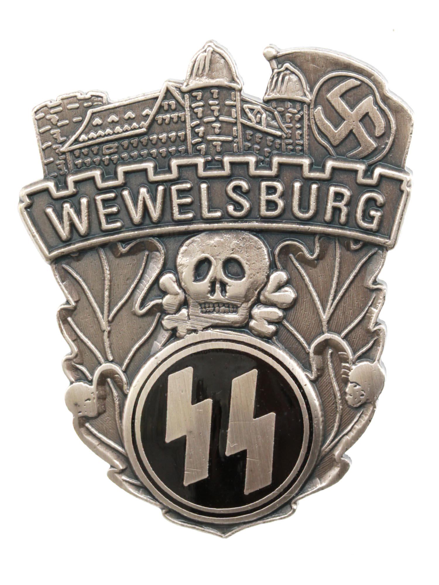 A GERMAN NAZI WEWELSBURG CASTLE SS ACADEMY BADGE: A German Third Reich Wewelsburg SS Academy badge with engraved images of a castle and a swastika on top, inscription Wewelsburg, oak leaves, a skull with bones Totenkopf in the middle, and an enameled