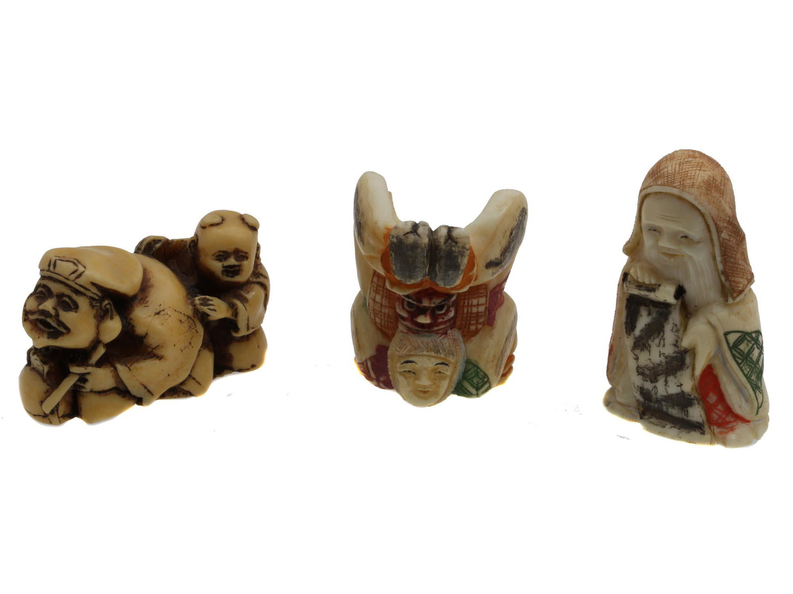 A SET OF THREE ANTIQUE JAPANESE NETSUKES: The lot includes three Japanese early 20th-century netsukes: a netsuke depicting Daikoku with Oni, a netsuke depicting an acrobat wearing a headdress with a demon mask, and a netsuke of Fukurokuju wit