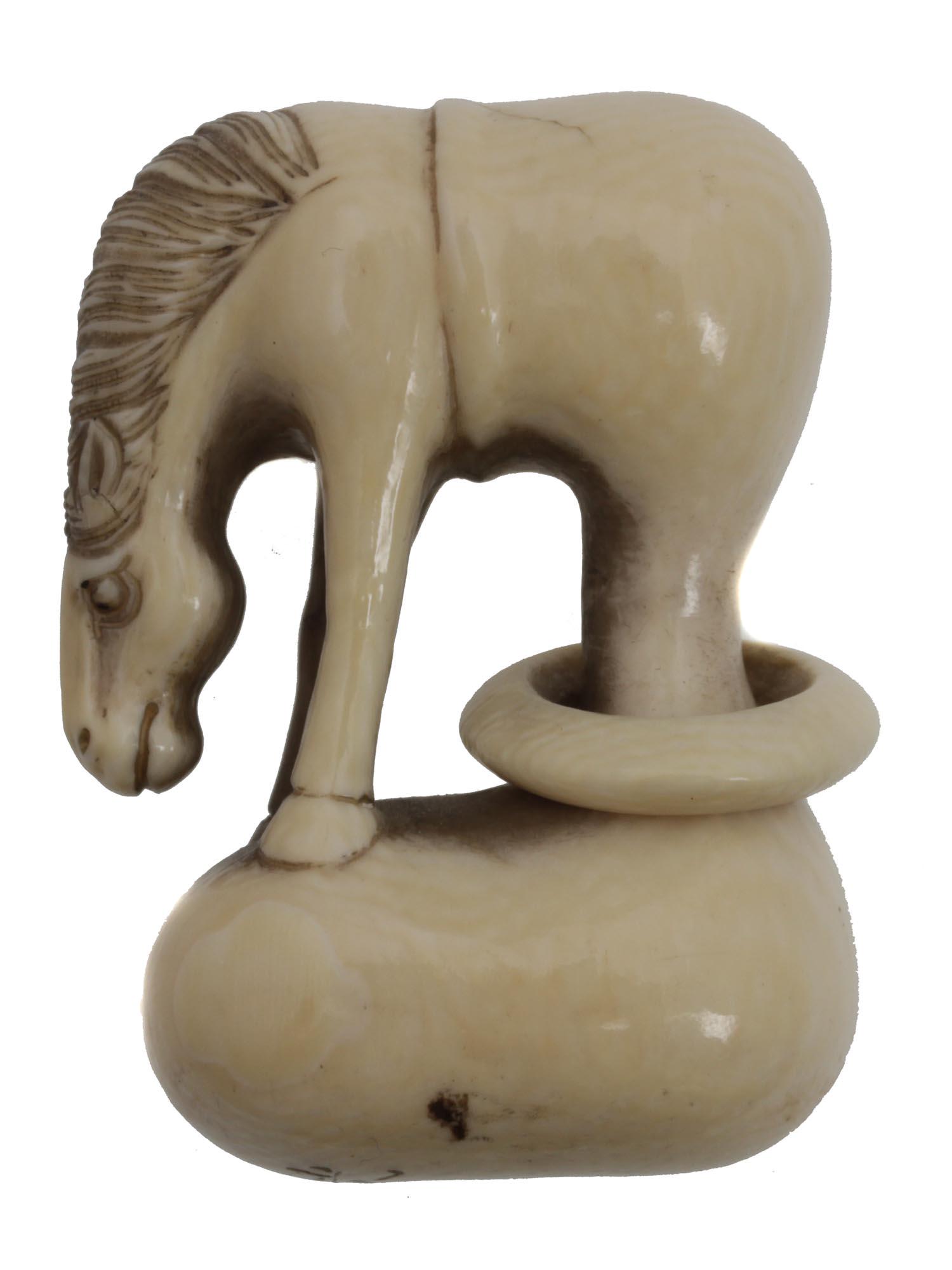 AN ANTIQUE JAPANESE CARVED NETSUKE OF A HORSE: A vintage Japanese netsuke depicting a horse with its head bowed. The horse's hind legs are in the pumpkin, which is a reference to the story of the Sennin Chyokoro carrying a pumpkin containing a mag
