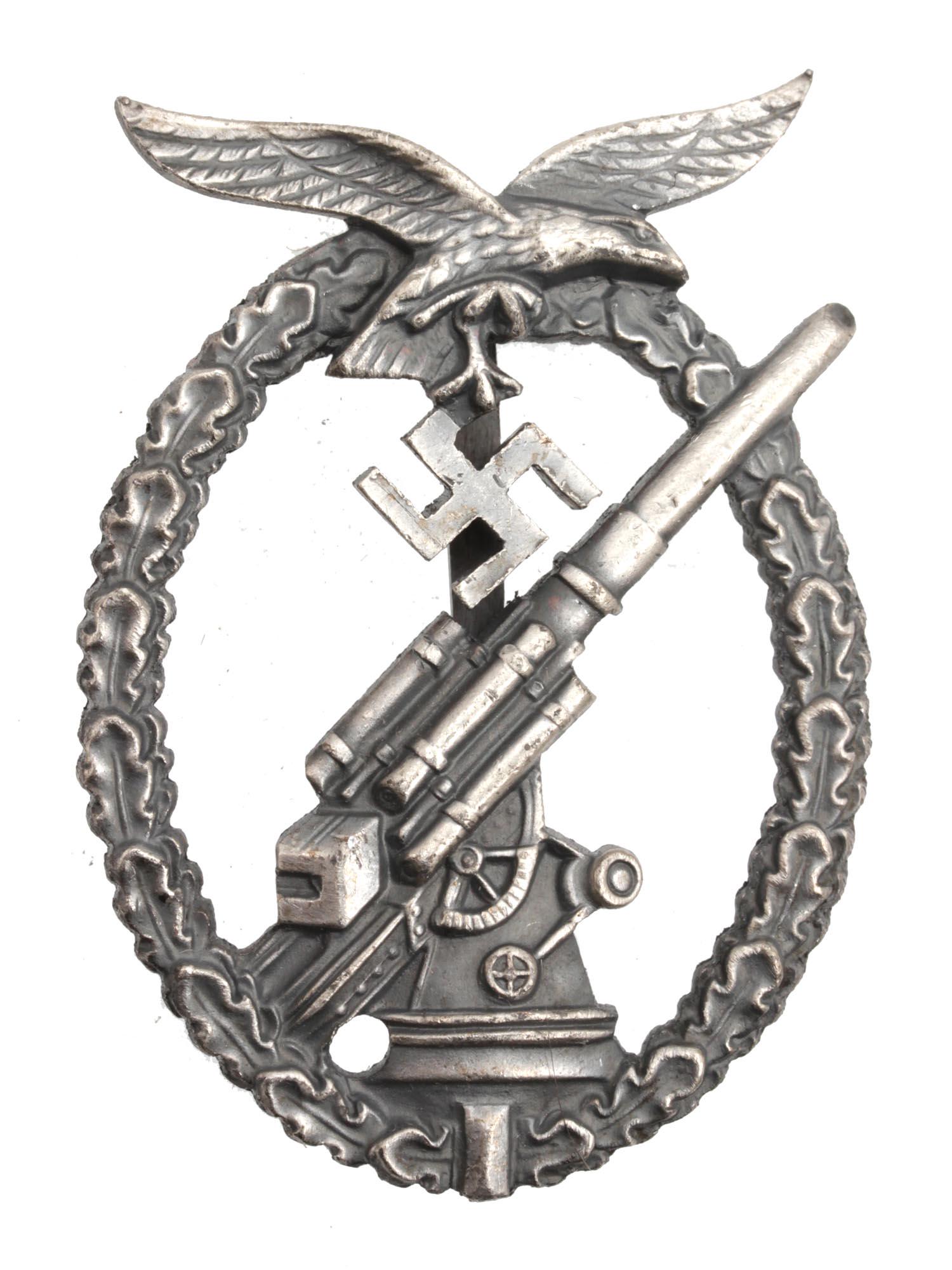 A WWII GERMAN LUFTWAFFE ANTI AIRCRAFT BADGE: This is a rare Luftwaffe Anti-Aircraft Flak Battle Badge. The design of the badge consists of an oval-shaped wreath with a Luftwaffe eagle placed in the upper part. It has a 88 Anti-Aircraft gun insid