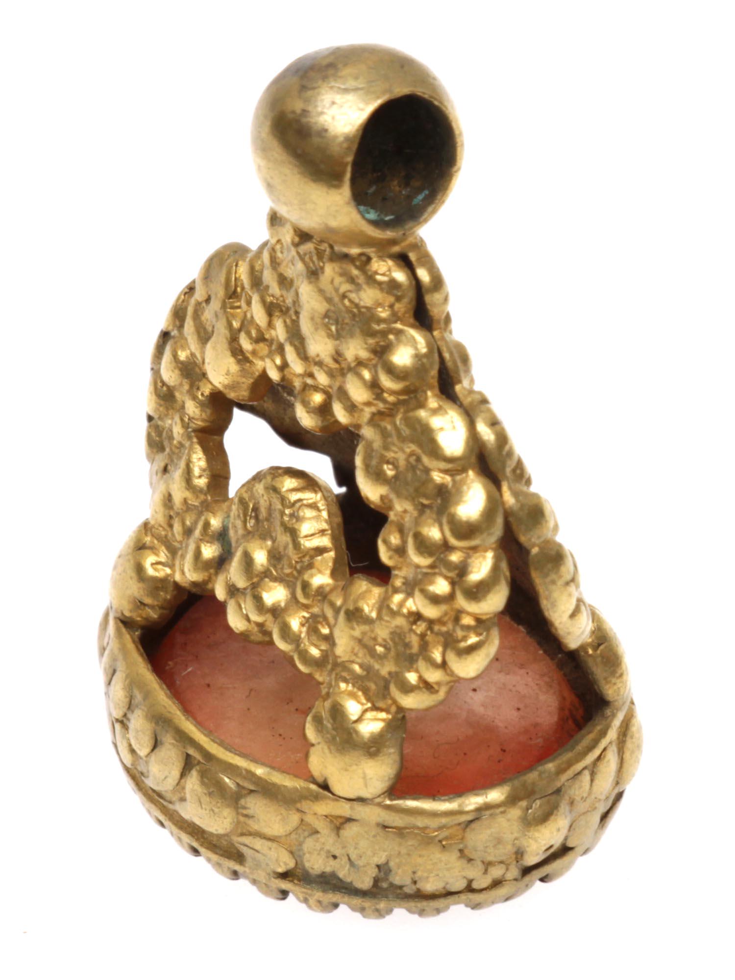 AN ANTIQUE BRASS SEAL MOUNTED WITH CARNELIAN: A 19th-century brass seal featuring an oval carnelian stone carved with an image of a bull. Possibly Spanish. Dimensions: H: 1 1/4 in.