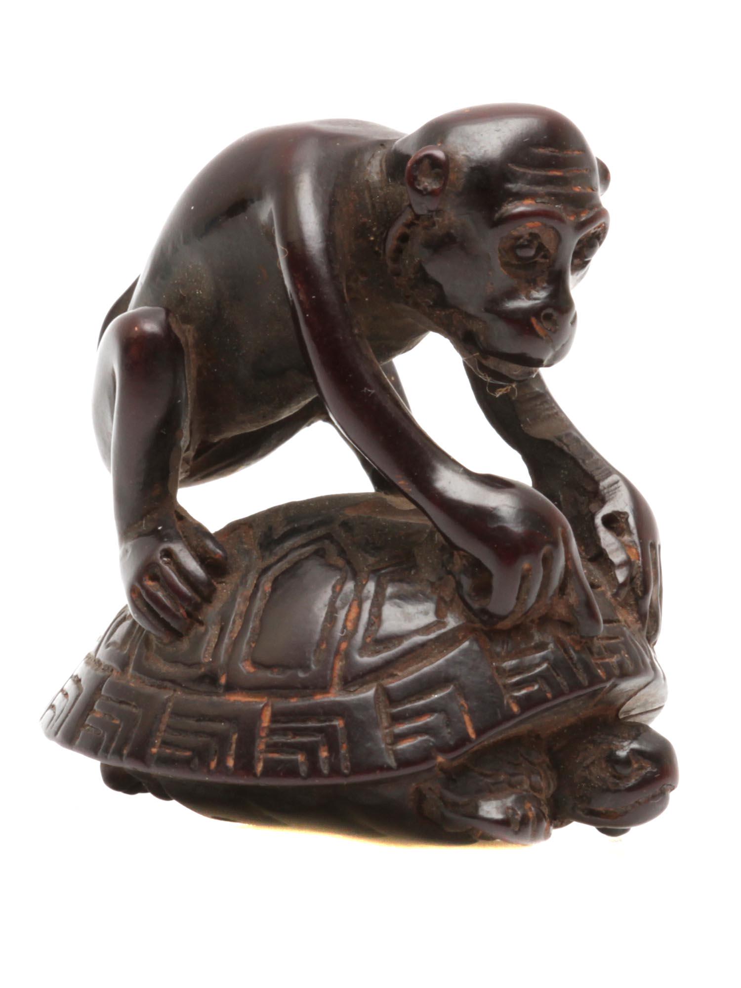 AN ANTIQUE JAPANESE WOOD NETSUKE MONKEY ON TURTLE: Original antique Japanese netsuke hand-carved from dark wood. Depicts a playful monkey sitting on a turtle shell. Circa: the late 19th to early 20th century. Dimensions: H: 1 5/8 in.