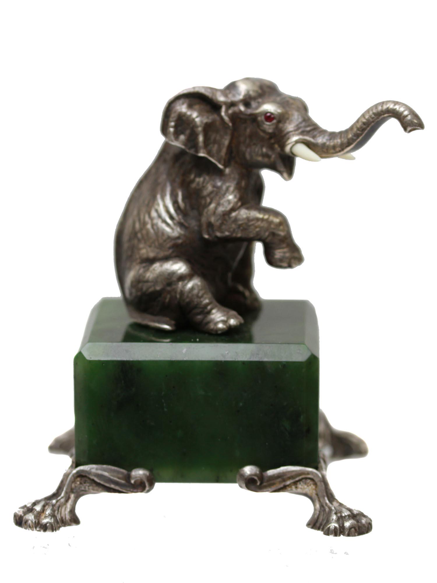 A RUSSIAN ELEPHANT FIGURE SILVER JADE RUBY: A Russian amazing Silver figurine of a sitting elephant, with eyes made of ruby, placed on a square jade pedestal with four silver legs. Marked with Russian hallmarks, 84 Silver mark, Kokoshnik, and o