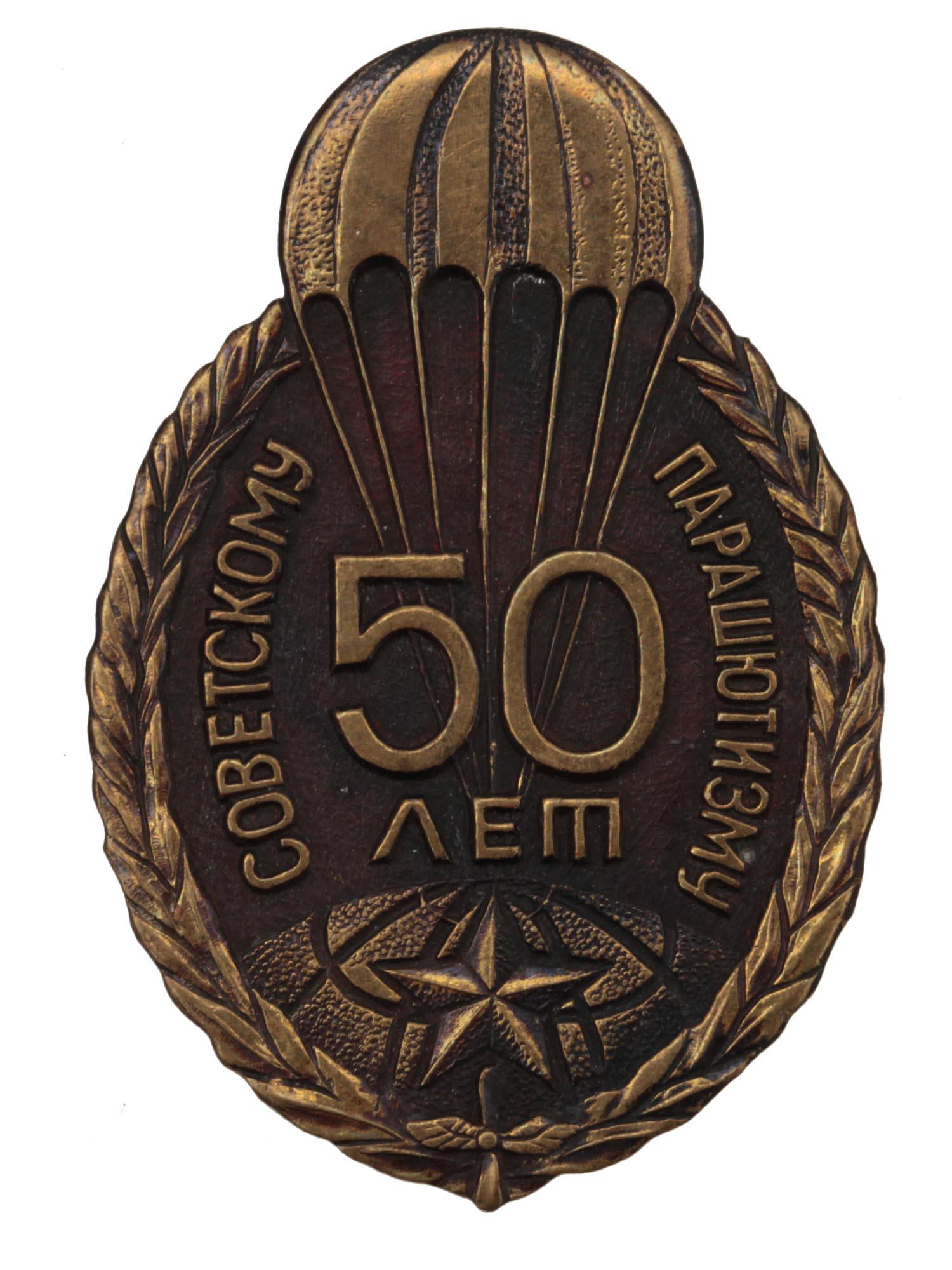 A BRONZE RUSSIAN SOVIET COMMEMORATIVE PIN: A bronze badge commemorating "50 years of Soviet skydiving". In the center of the badge is the image of a parachute over the globe. A five-pointed star is attached to the parachute. The badge is borde
