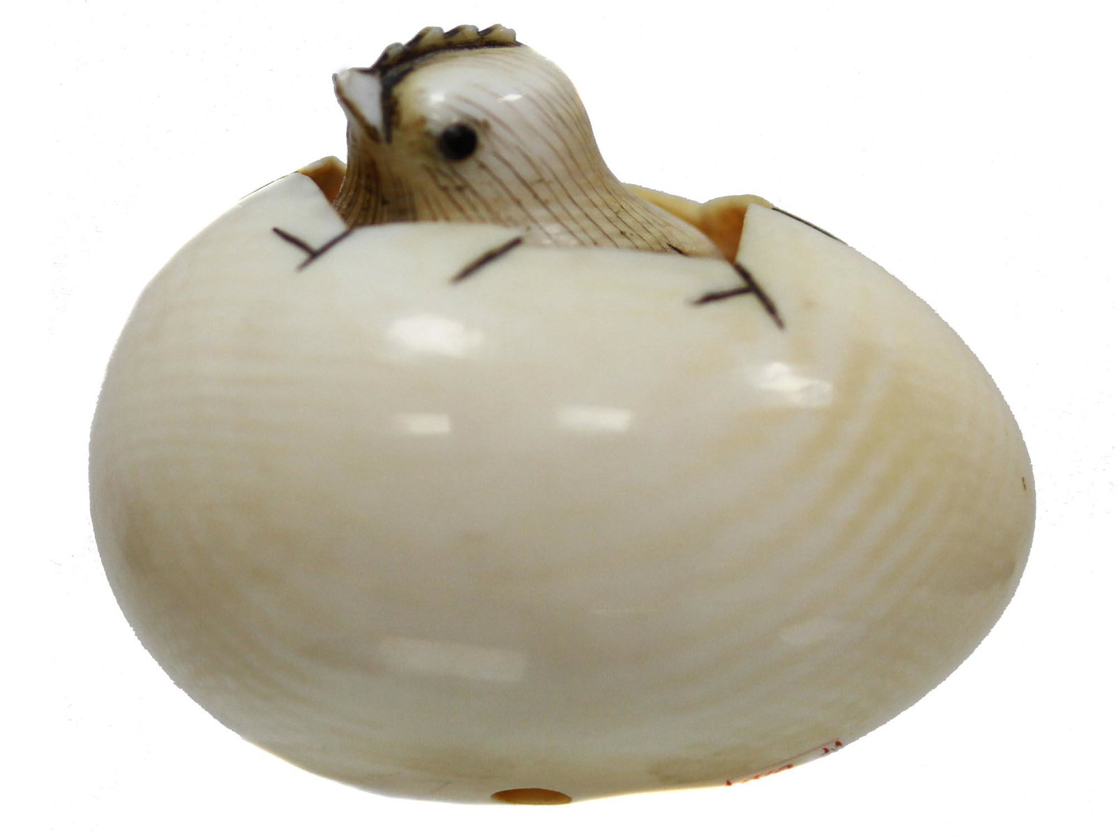 AN ANTIQUE JAPANESE NETSUKE CARVED EGG WITH CHICK: An antique Chinese hand-carved from natural materials delicate figurine in the form of a chick hatching from an egg, the chick being moveable. Signed in Hieroglyphs, and marked in red seal on the bott